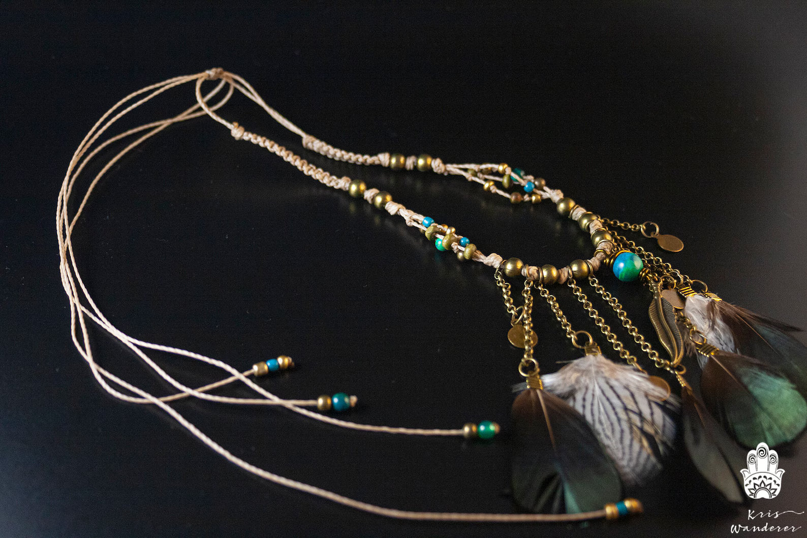 Decorative headband with beads and feathers on a dark background