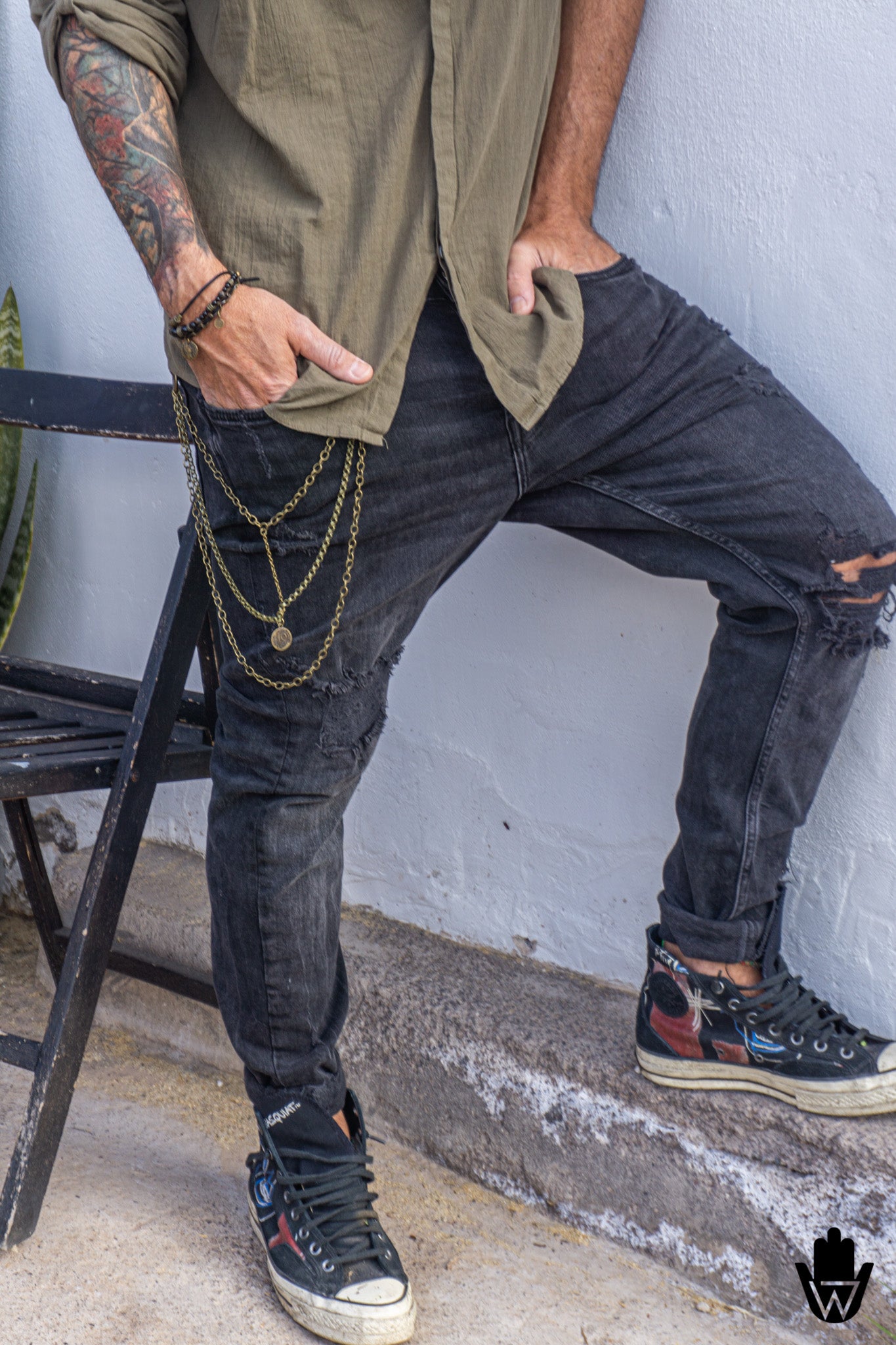 man wearing urban clothes with boho jewelry and a layered chain for pants