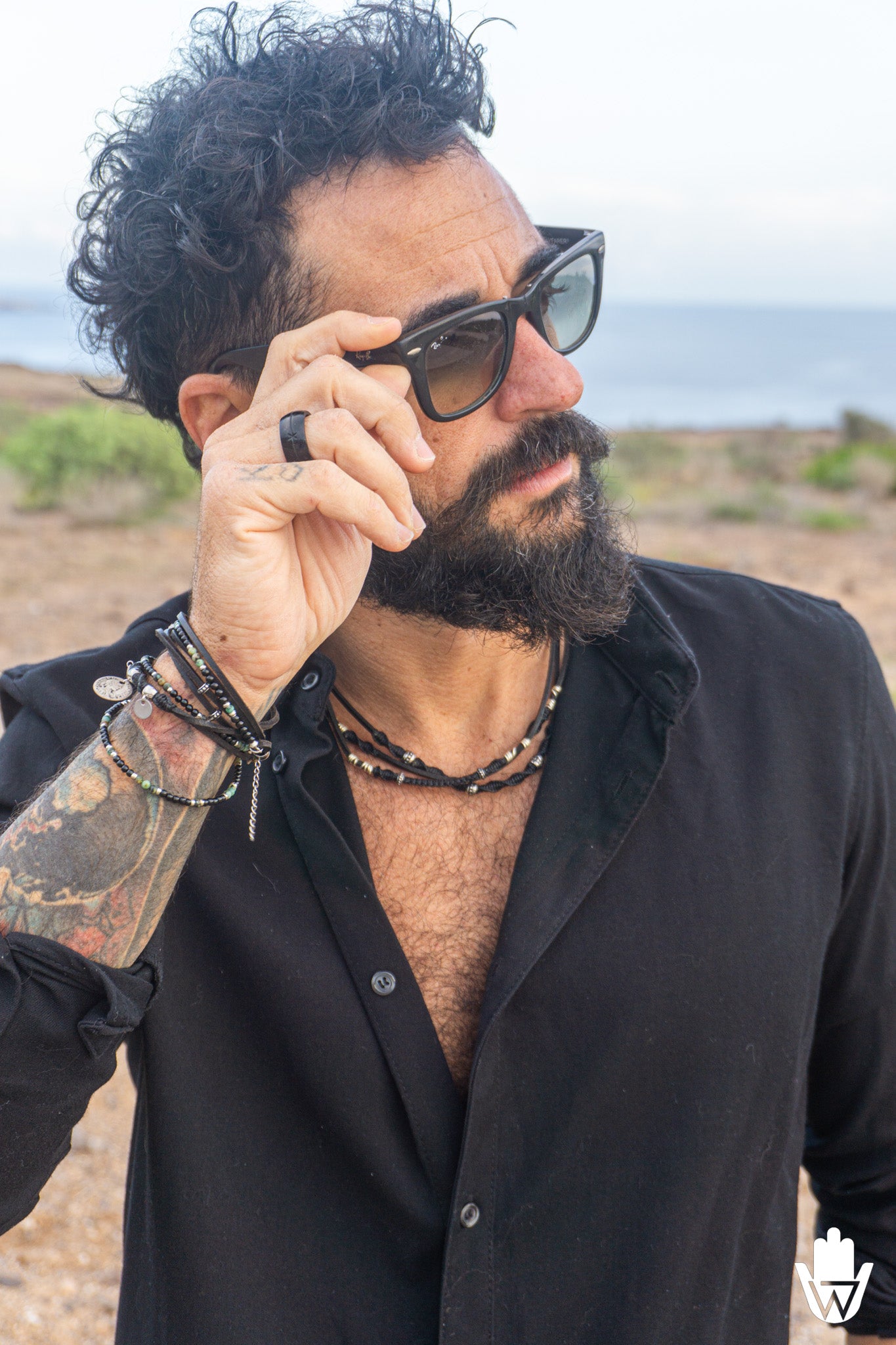 man all in black with layered bracelet and choker necklace
