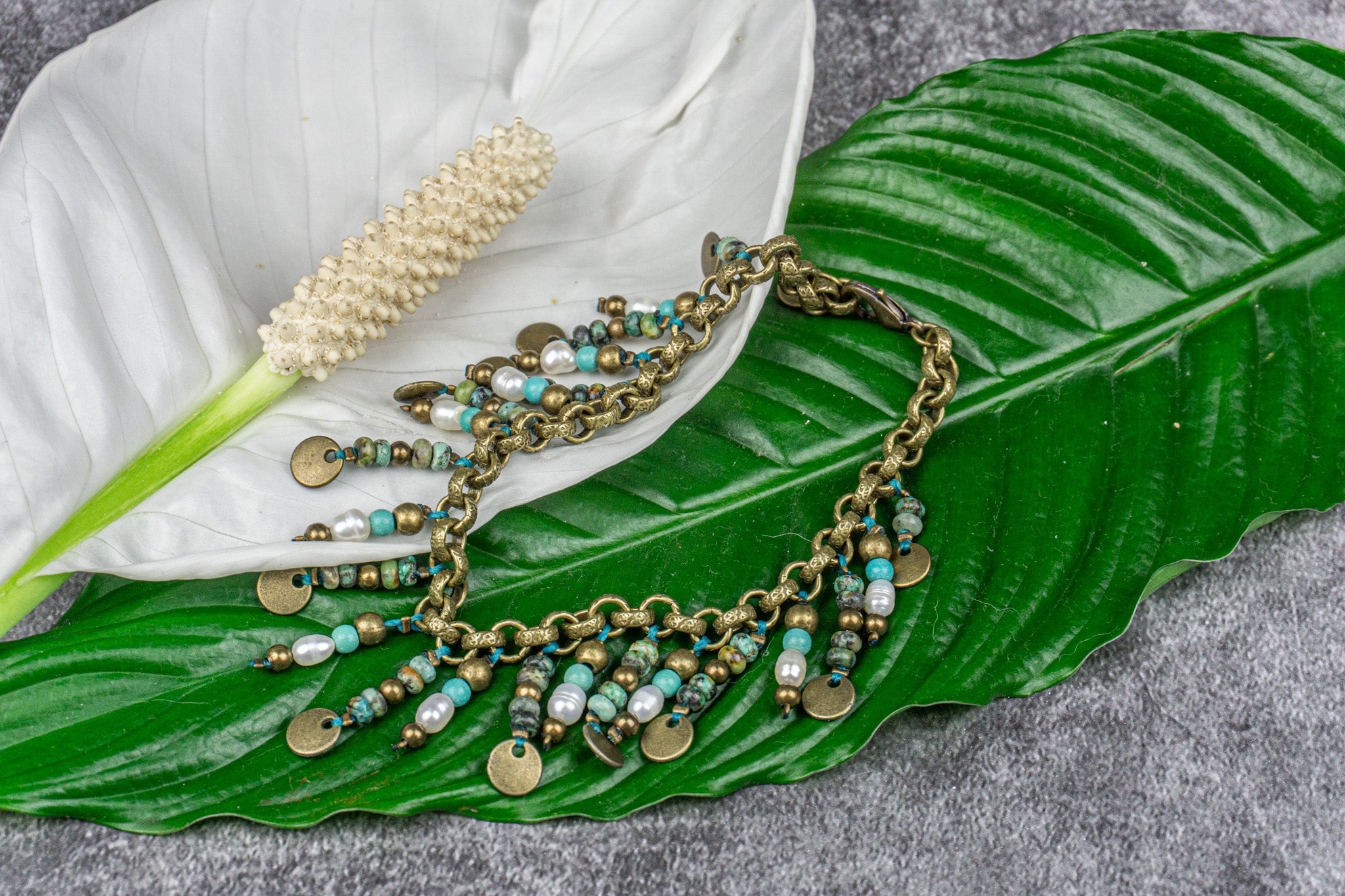 Elegant anklet made with African turquoise jasper, pearls, and brass, featuring 22 dangling charms – Wander Jewellery