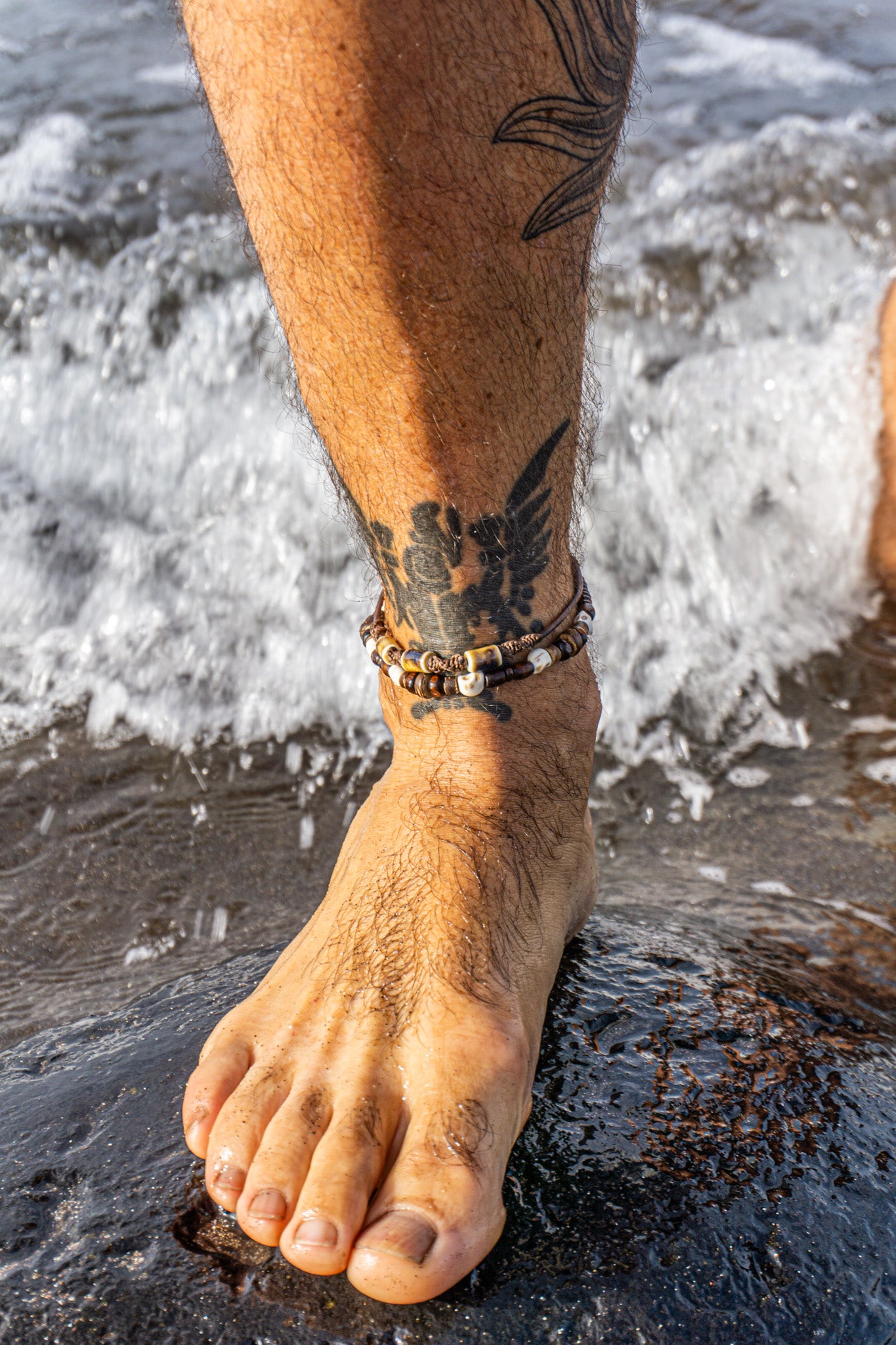 Two-layered men’s anklet made of leather, ceramic beads, wooden and coconut elements, with pirate skull charms – Wander Jewellery