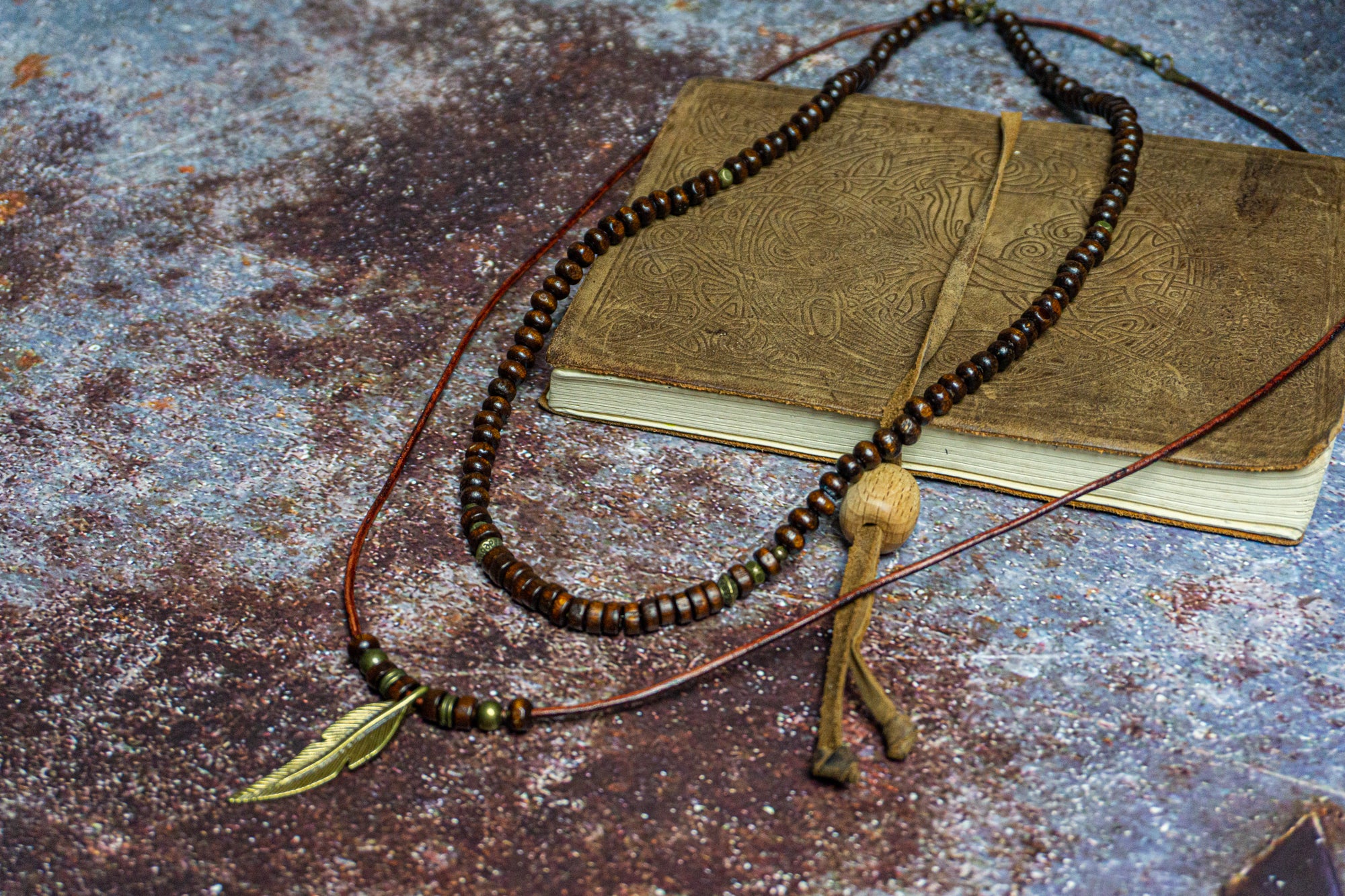 layered necklace set made of a wooden bead necklace and a leather necklace with a bronze feather as a pendant- wander jewellery
