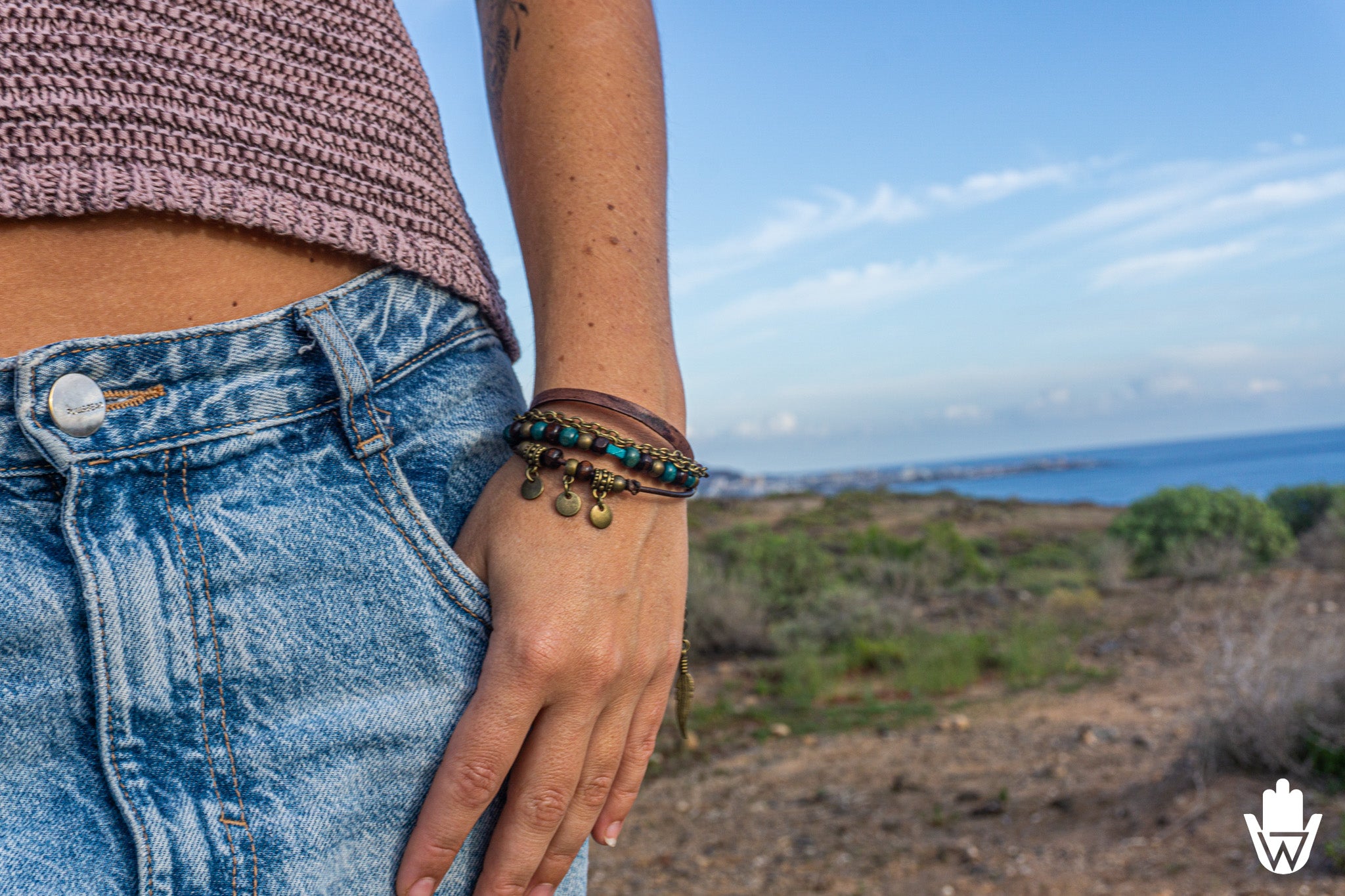 woman wearing a bracelet set with a scenic background of ocean and sky