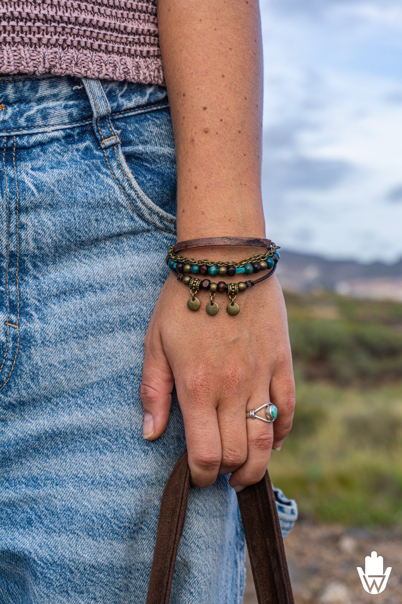 women wearing a colorful bracelet set and a ring with a scenic background