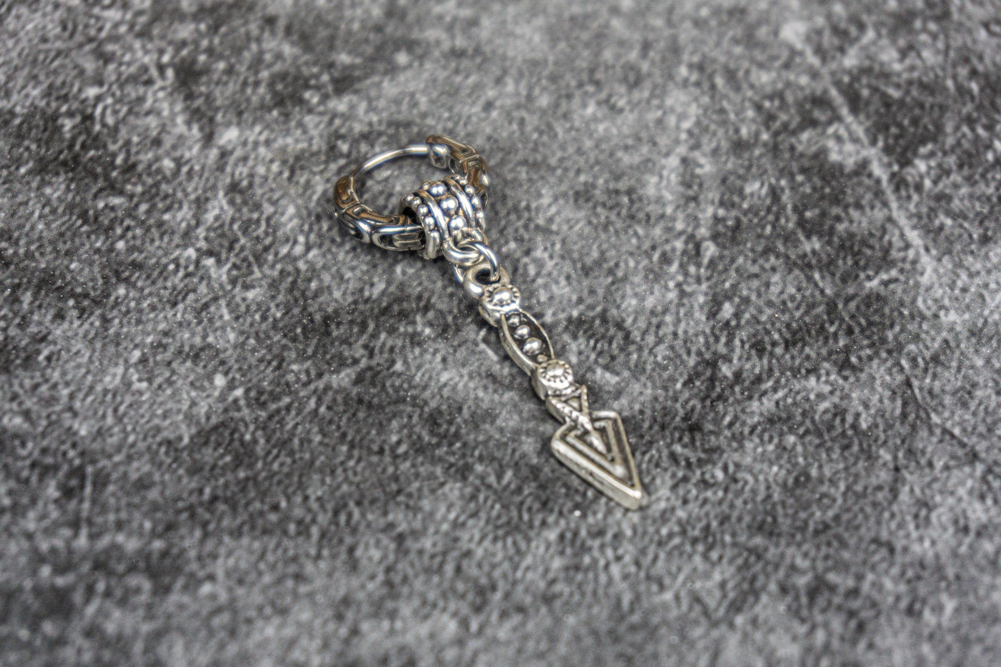 stainless steel hoop earring with a long dangle arrowhead charm- wander jewellery