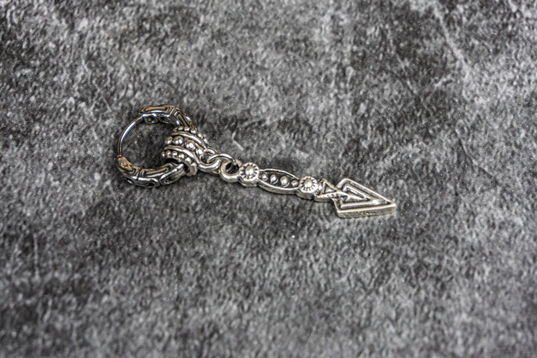 cool tribal stainless steel hoop earring with a long dangle arrowhead charm- wander jewellery