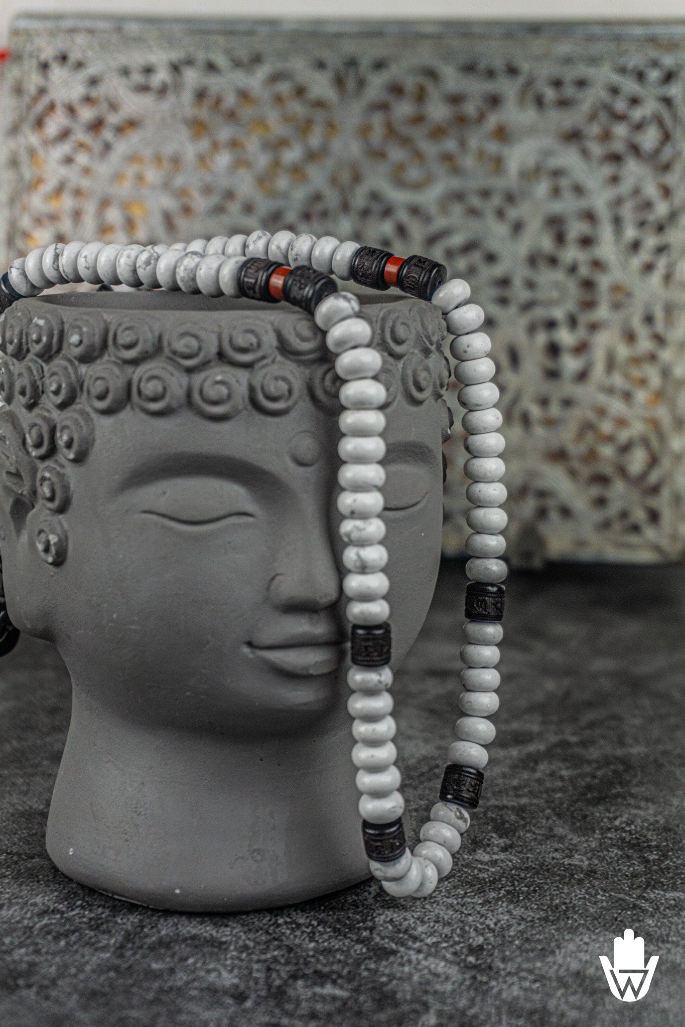 white necklace on a decorative buddha head
