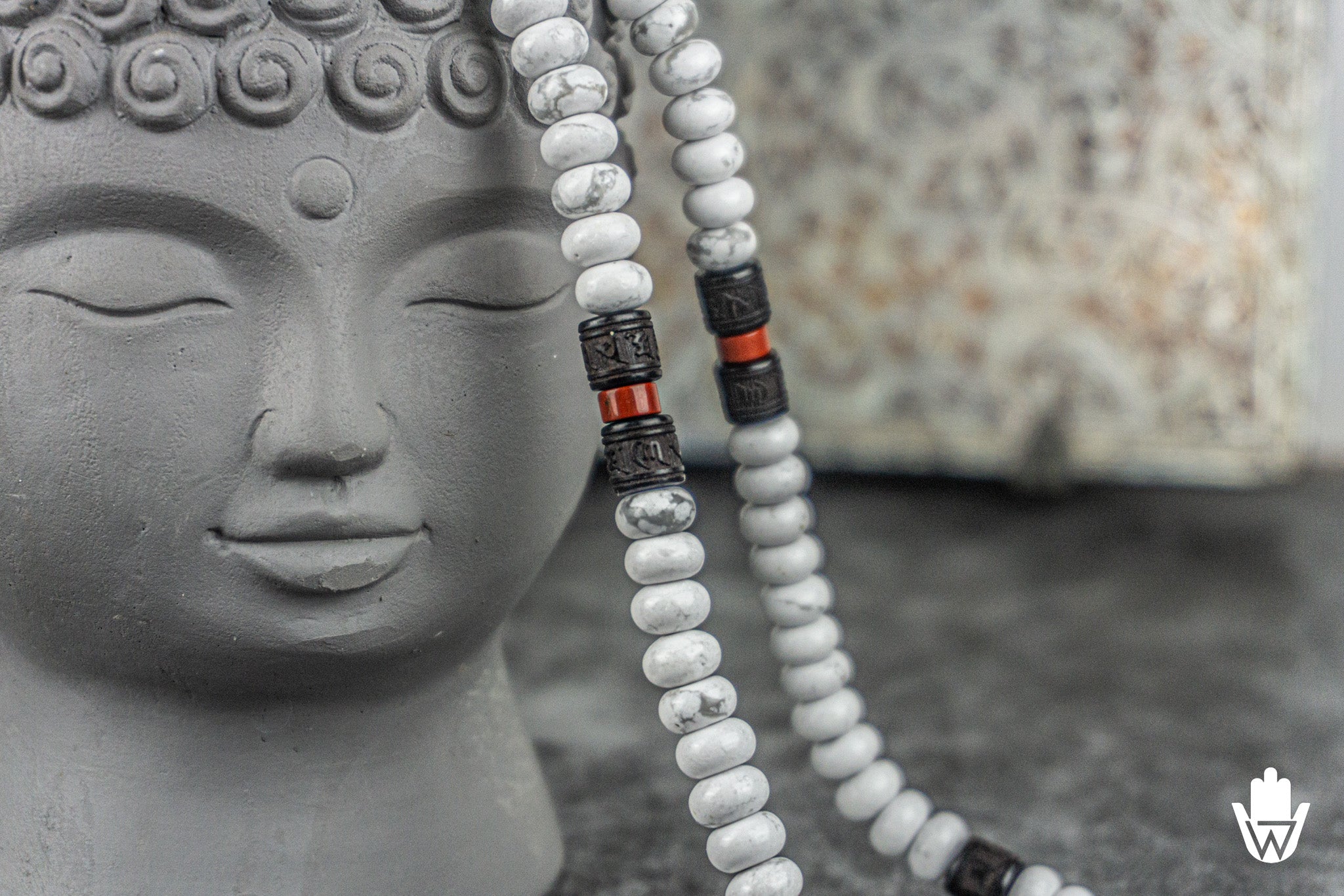 close up of a necklace made of white beads and wooden dark beads with oriental symbols