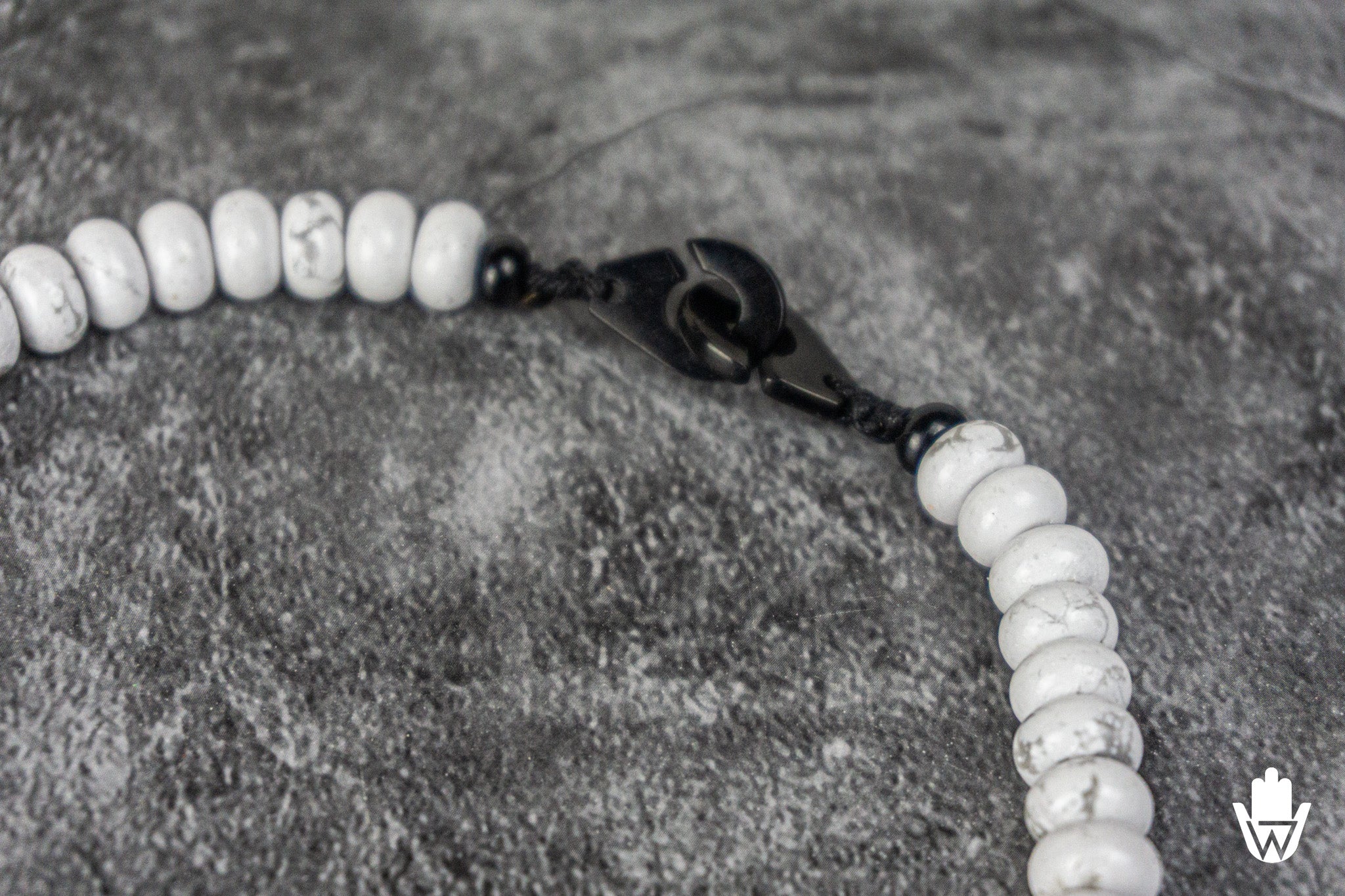 close up of a black stainless steel closure of a white piece of jewelry