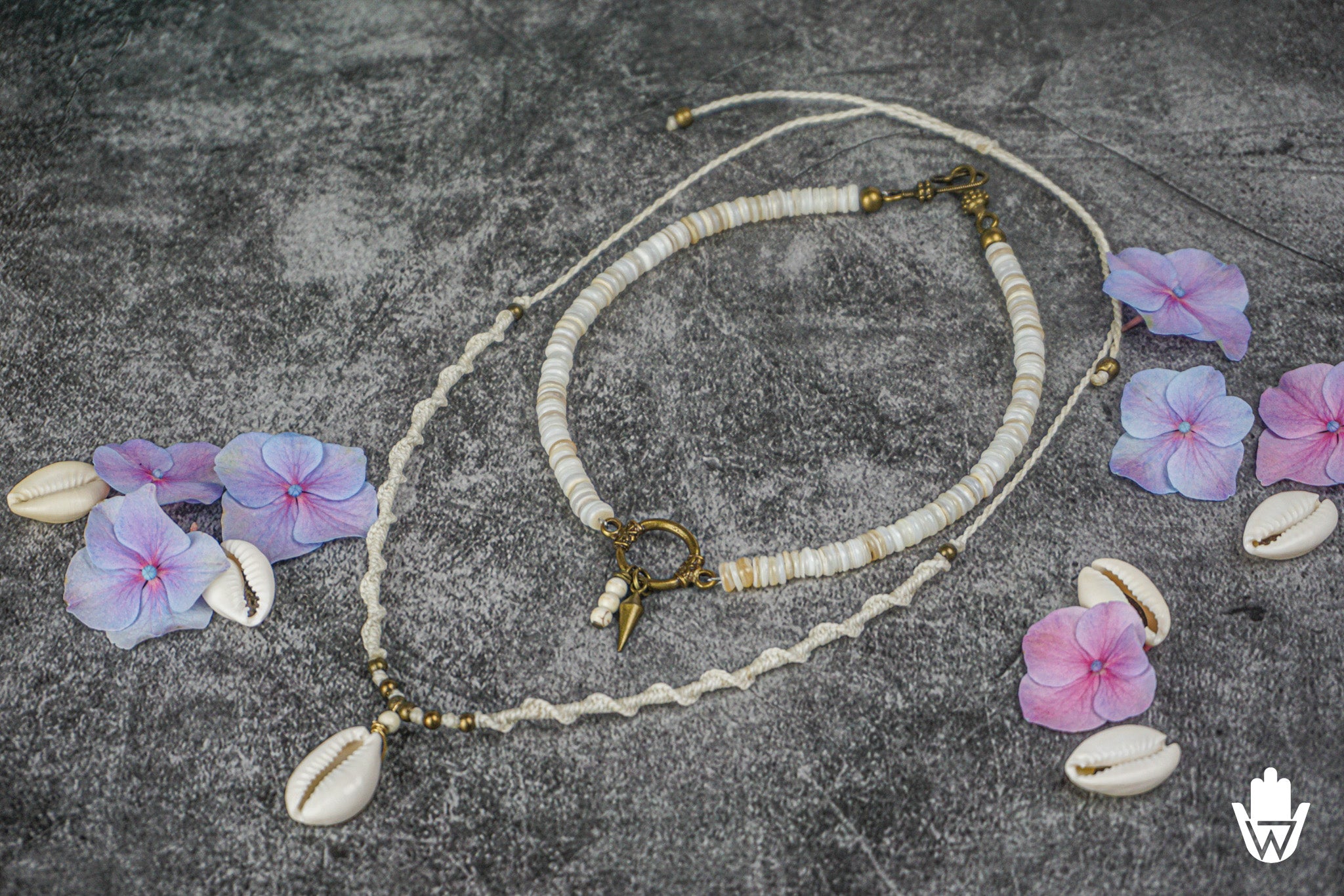 two white matching necklaces with seashells