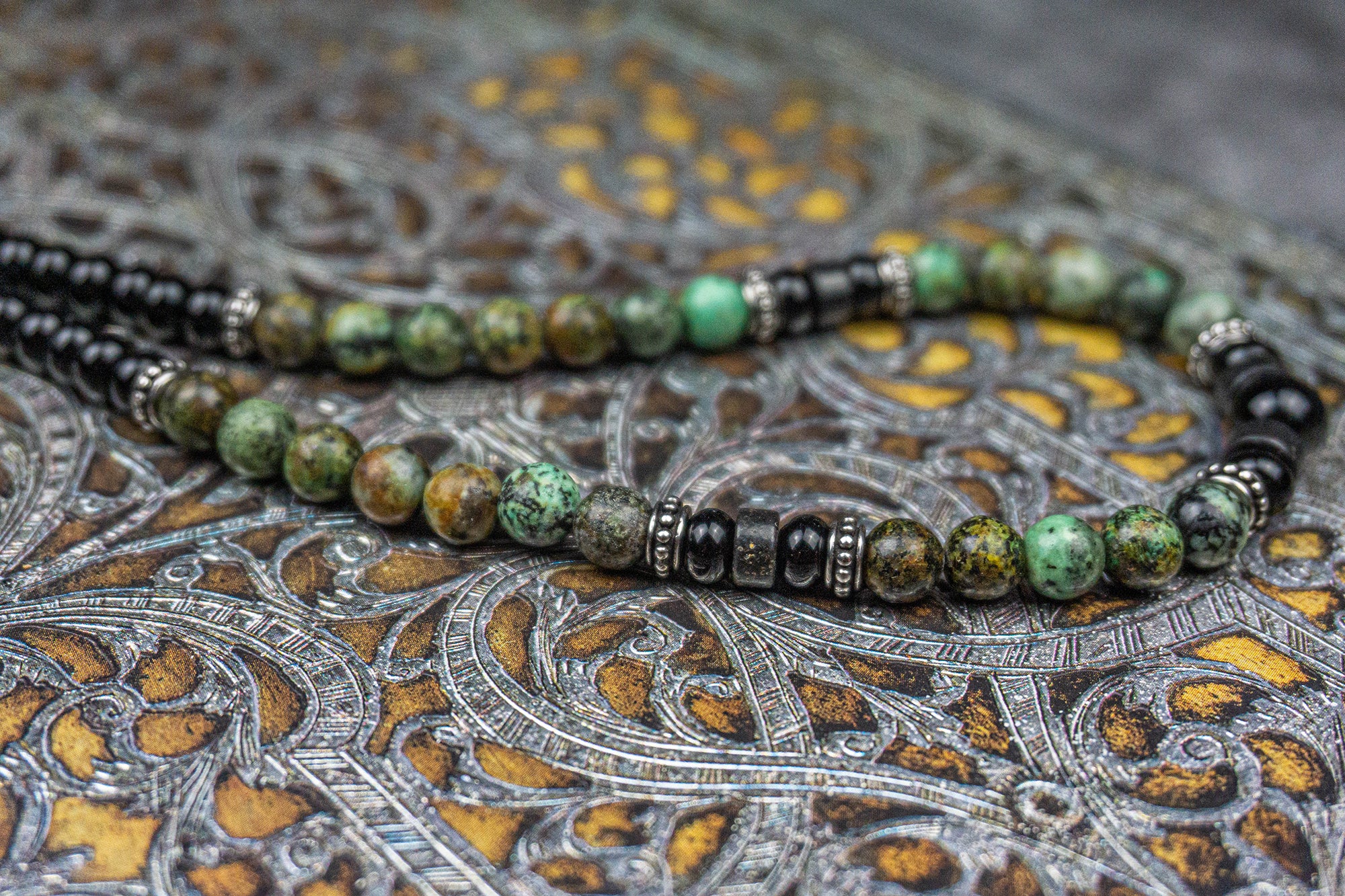 Close picture of a necklace made of black onyx and green african turquoise gemstones, and stainless steel spacer beads