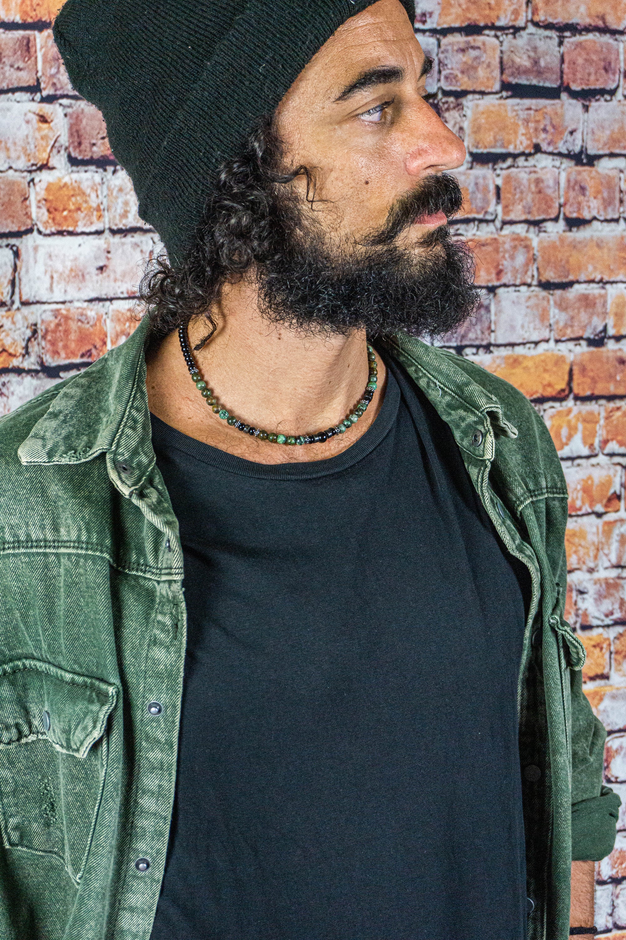 curly men waering a black and green gemstone beads choker necklace with some stainless steel details