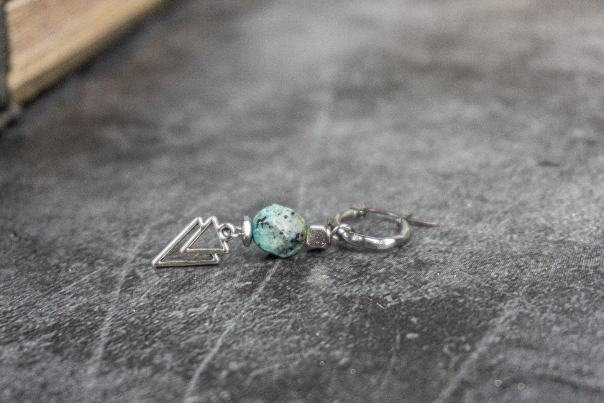 stainless steel geometric earring with a green jasper gemstone with speckles of black.