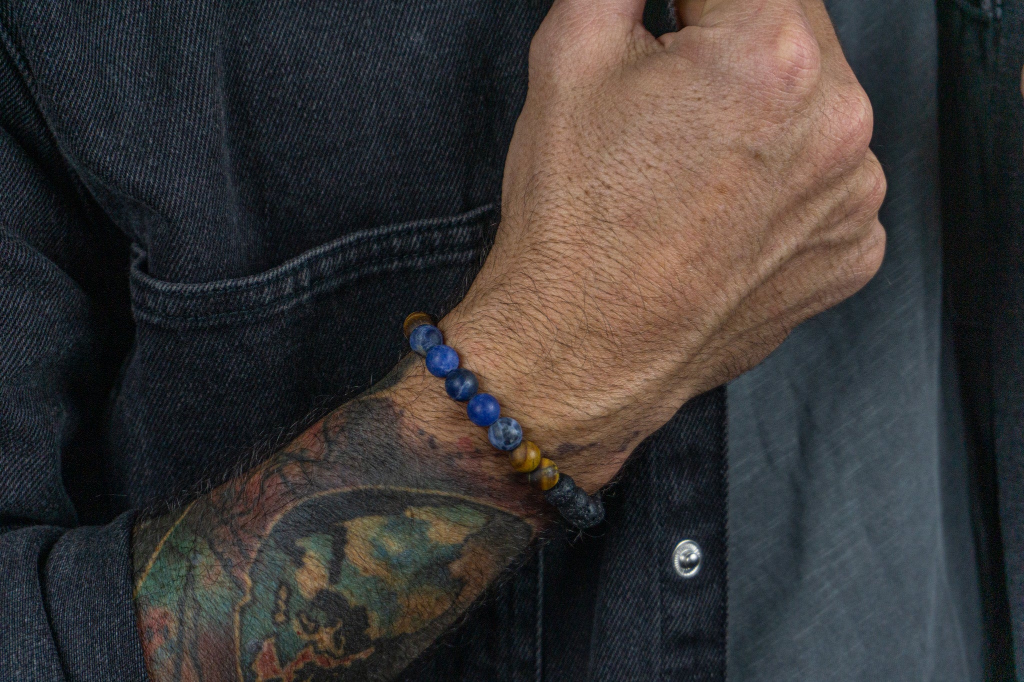 bracelet made of lava stone tiger eye sodalite, weared by a men with a black jacket