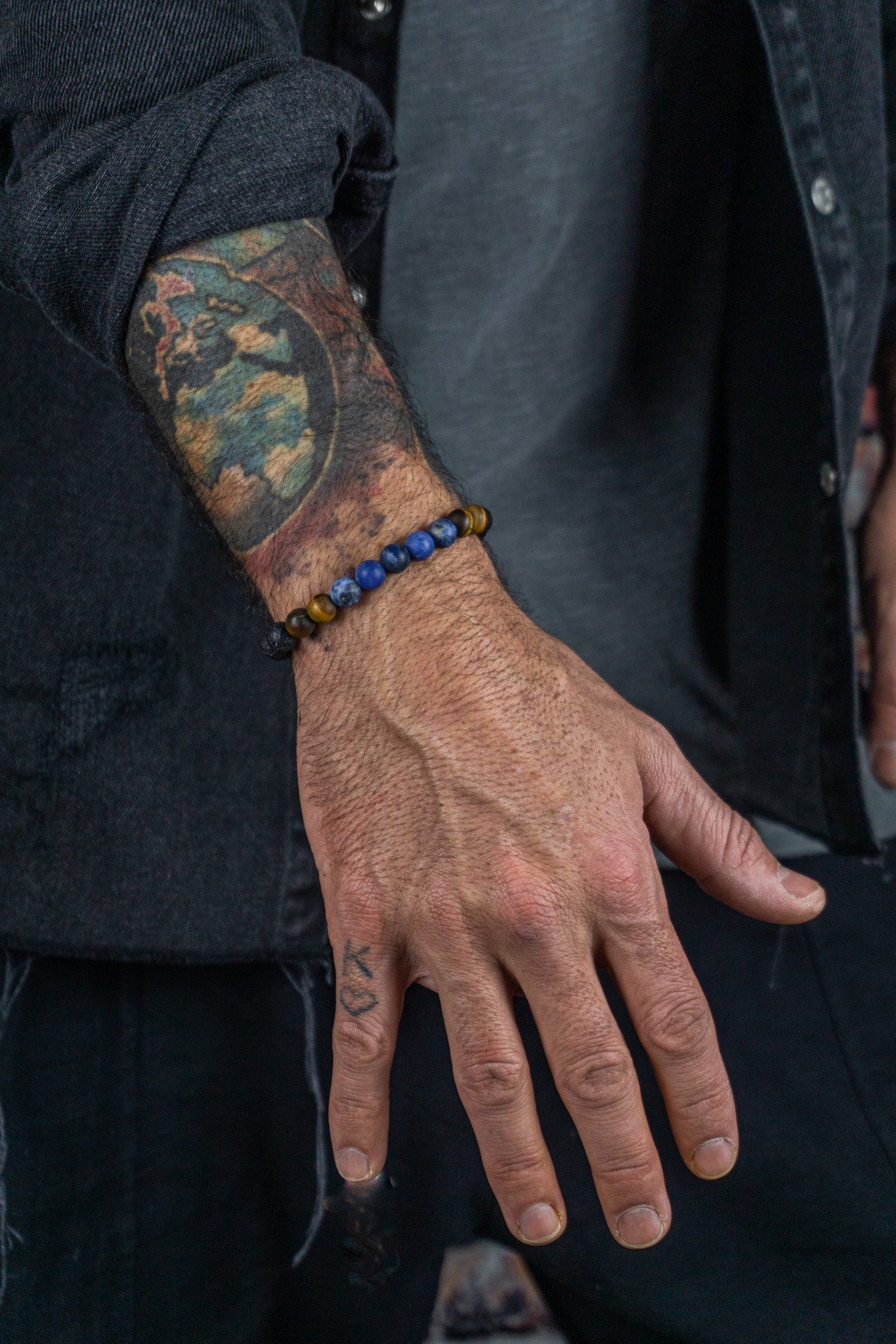 bracelet made of lava stone tiger eye sodalite, weared by a men with tatoos
