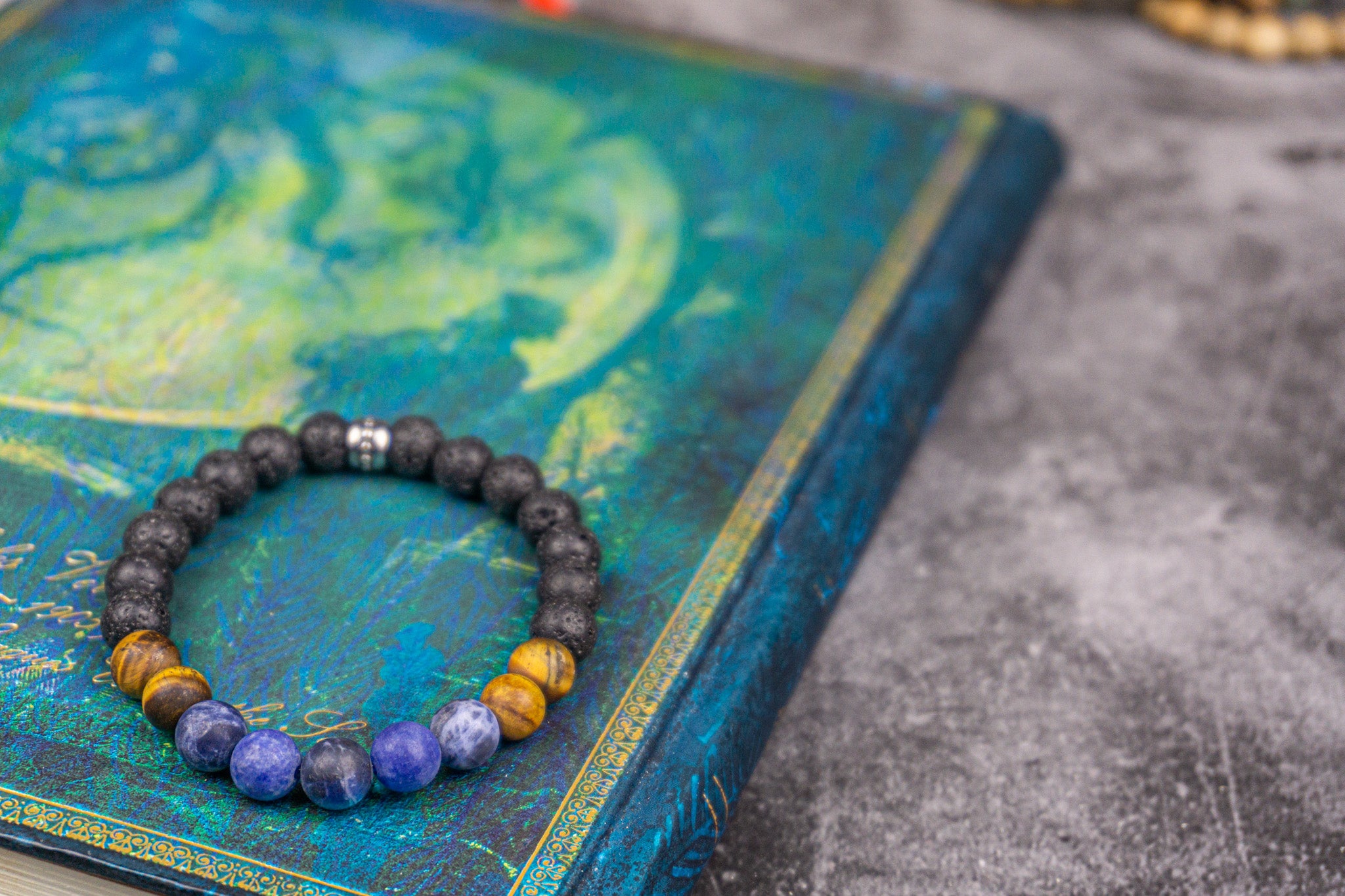 bracelet made of lava stone tiger eye sodalite, on a blue book