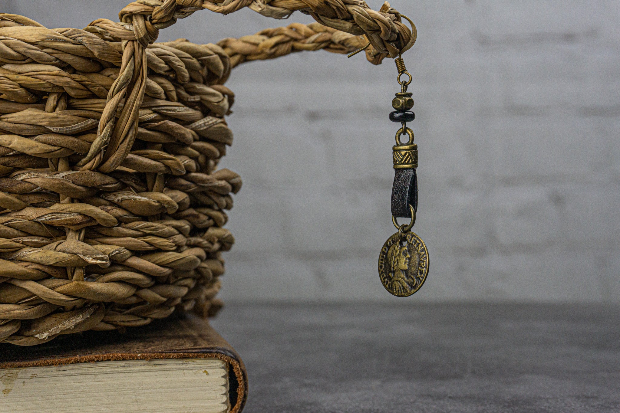 a pirate earring with leather, brass charm, onyx stone