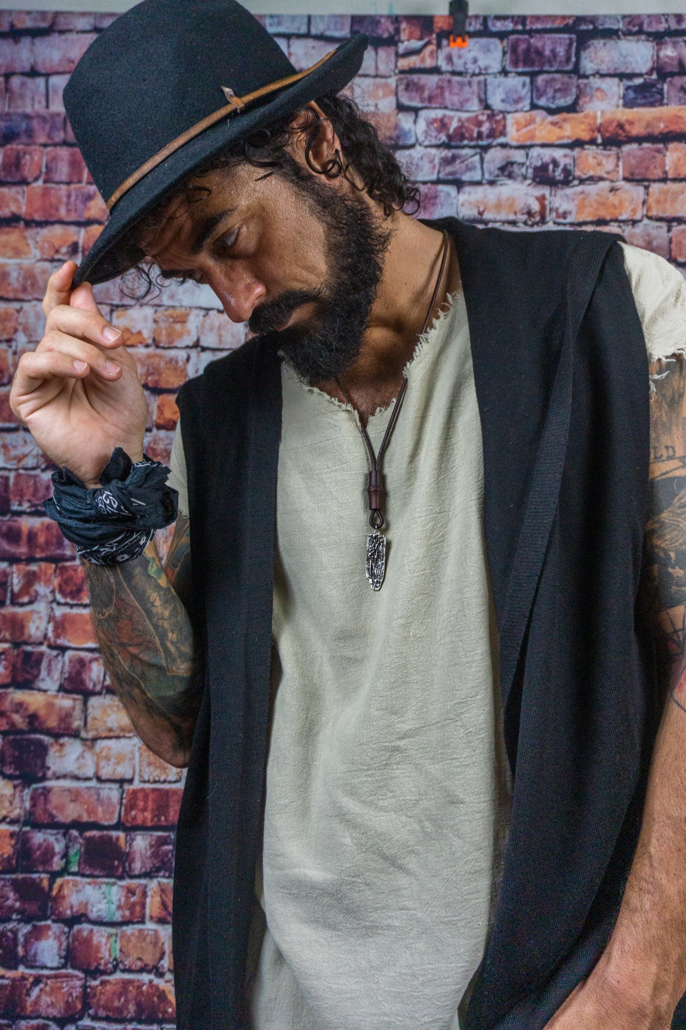 men wearing a long chunky leather necklace with a silver abstract pendant