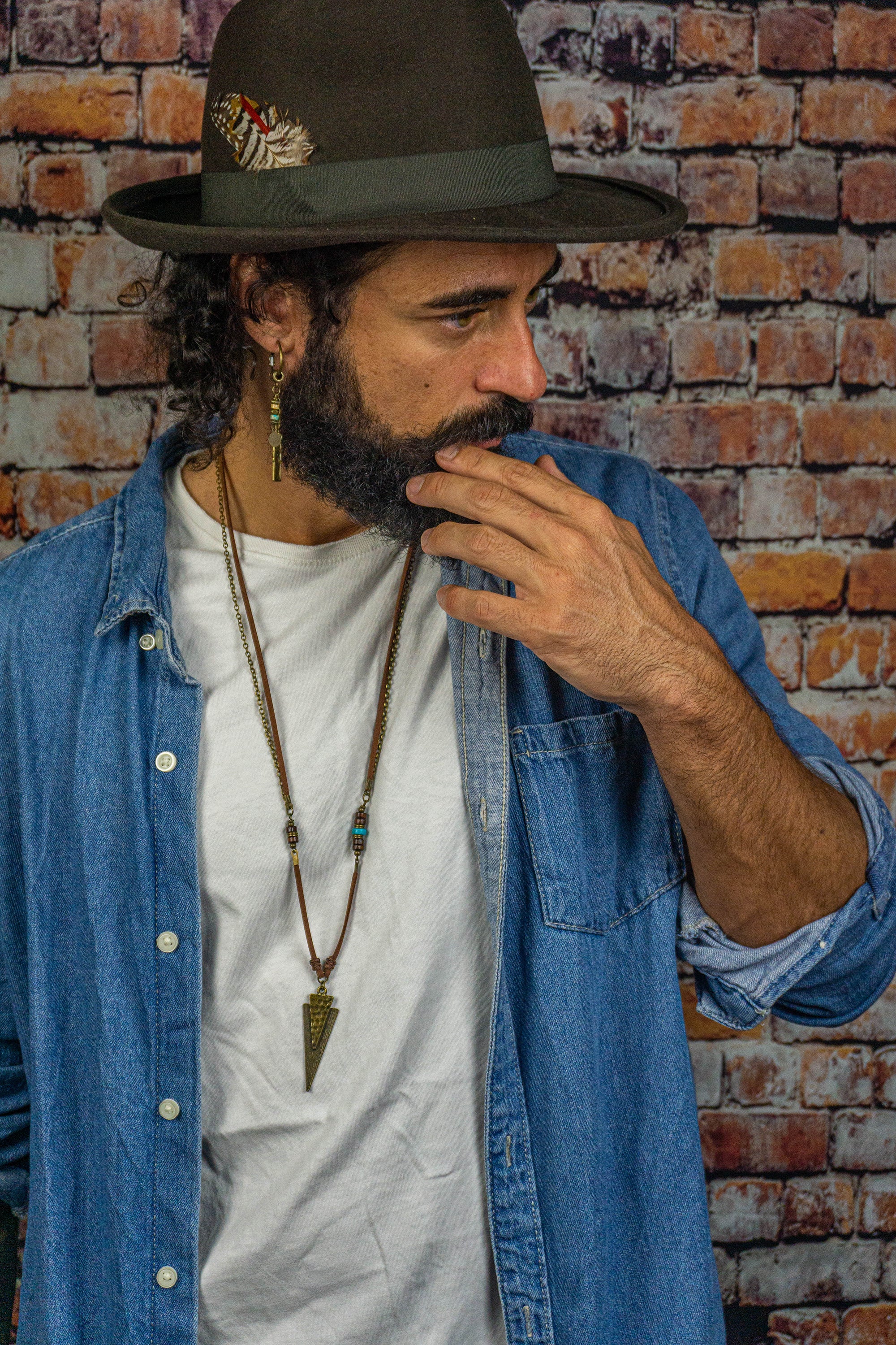 leather and chain necklace with a triangle arrowead antique bronze pendant and wood and turqupise gemstone beads detail