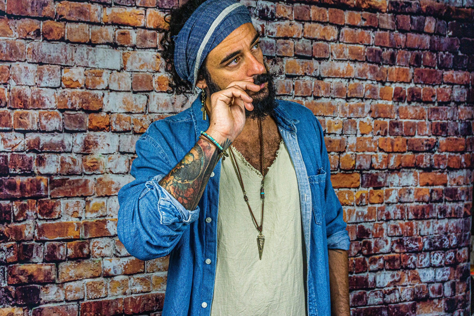 long leather and chain necklace with a triangle arrowead antique bronze pendant and wood and imperial jasper gemstone beads detail