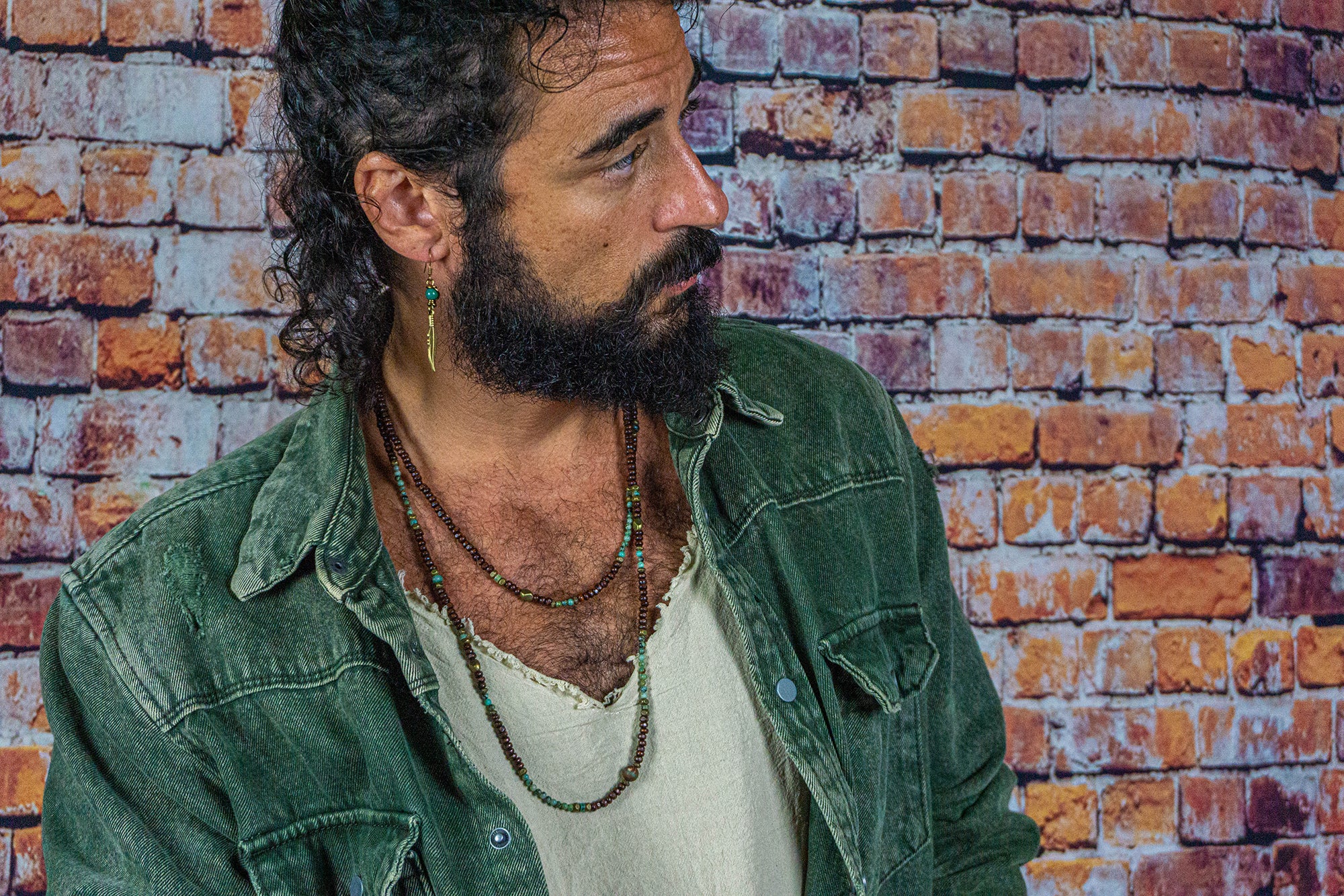 mens waering a long layered necklace made of wood and green gemstone bads- wander jewellery