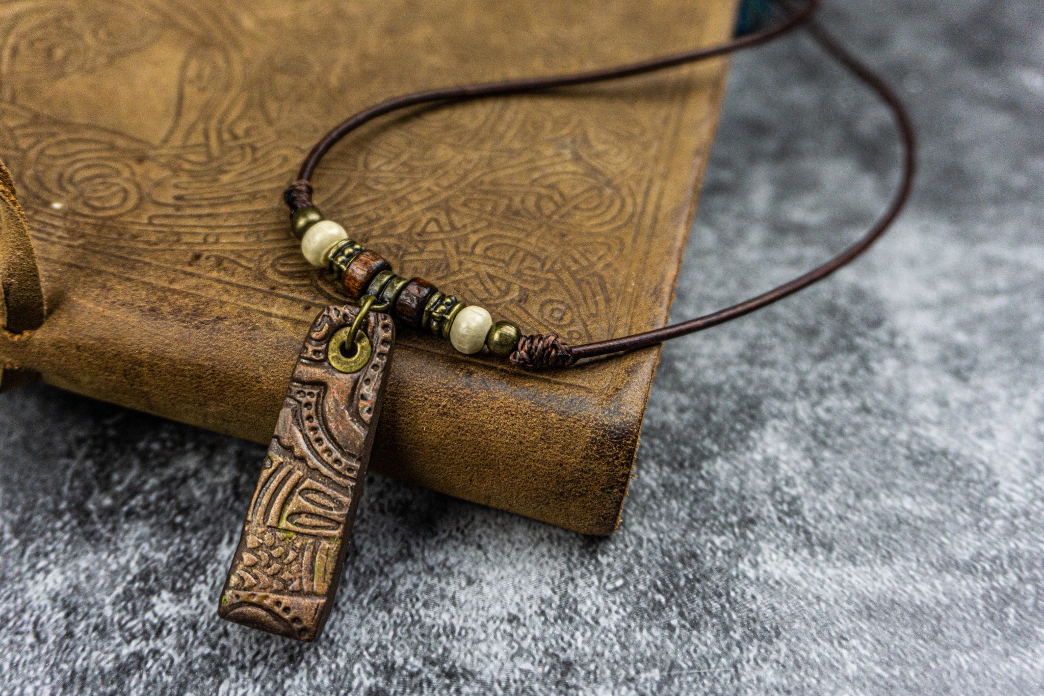 close picture of the pendant, made of polymer clay with a tribal texture