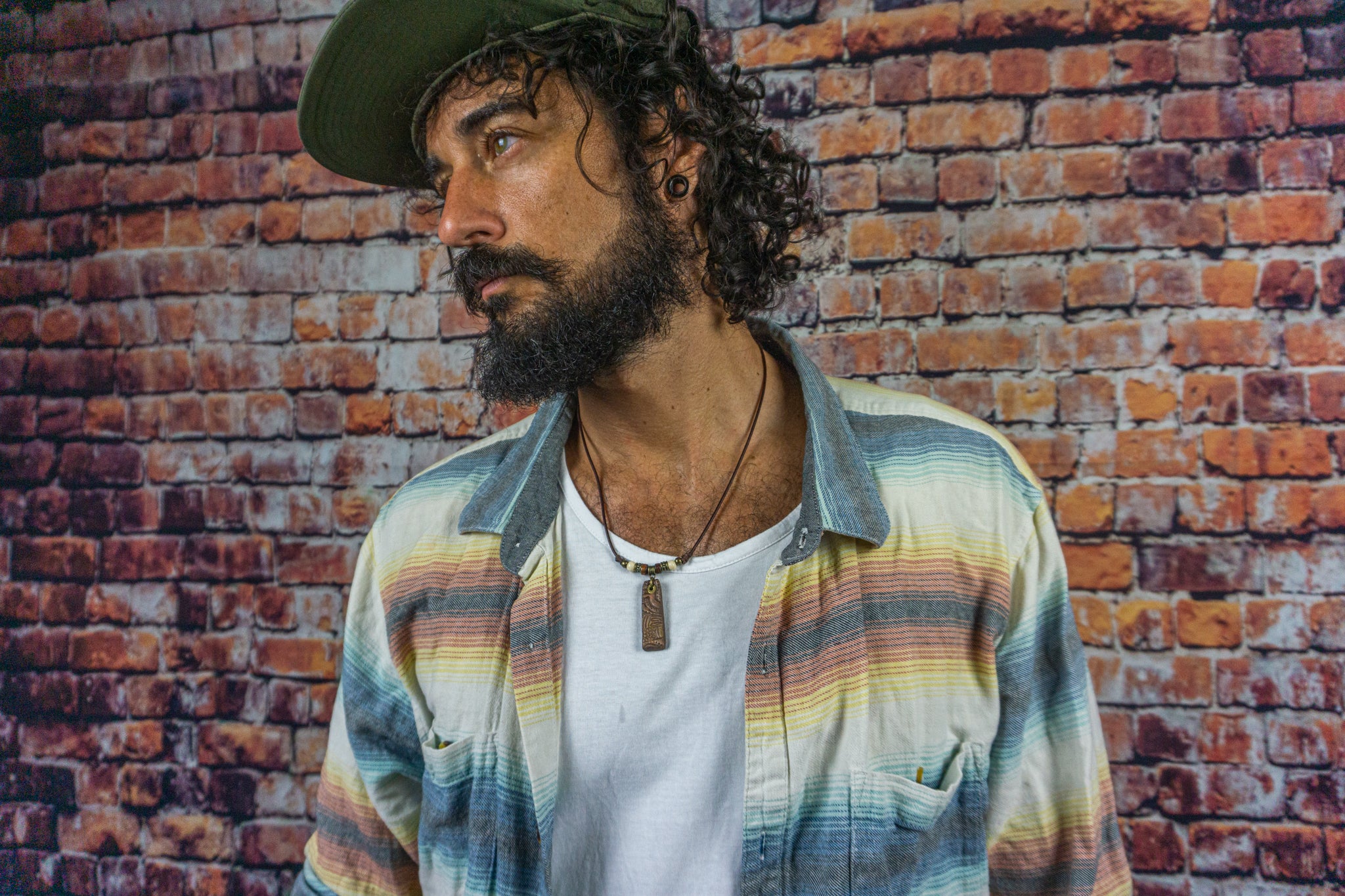 men wearing a simple minimalist leather short necklace with a tribal pendant