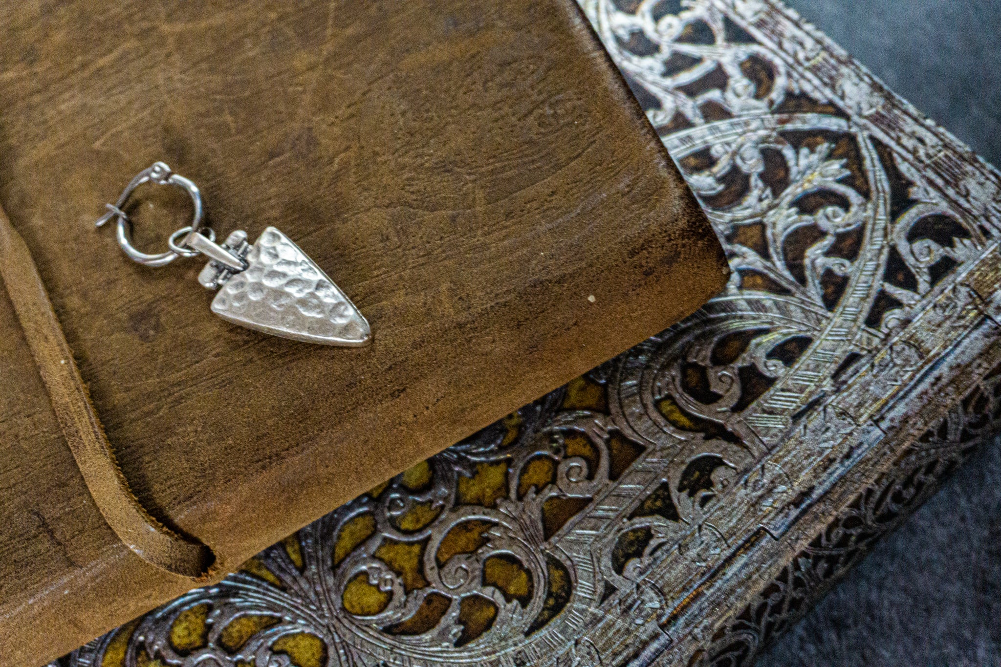 stainless steel hoop earring with a hammered triangle silver colored charm-wander jewellery