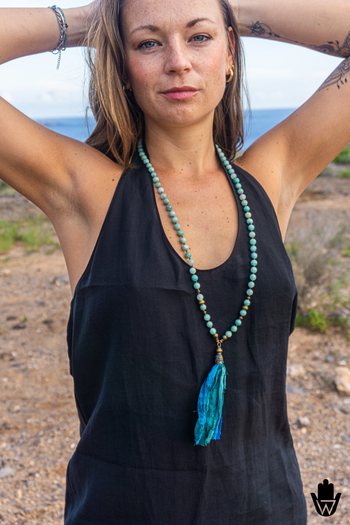 woman in black dress with long turquoise beaded necklace