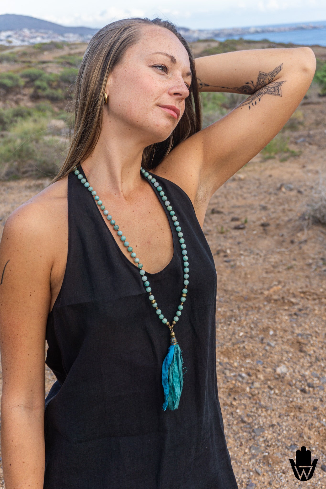 women posing in a natural lanscape with a long beaded tassel necklace