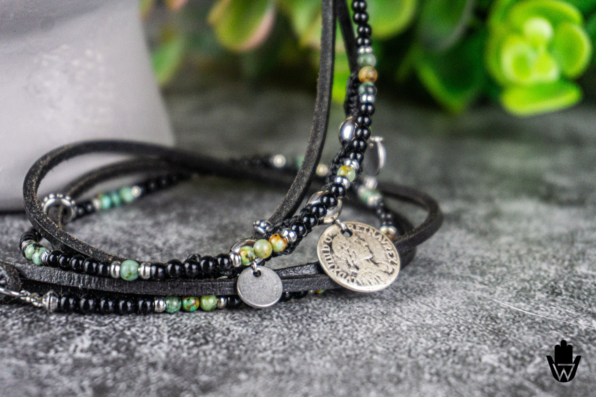 Multi-layered beaded bracelet with metal charms on a textured surface