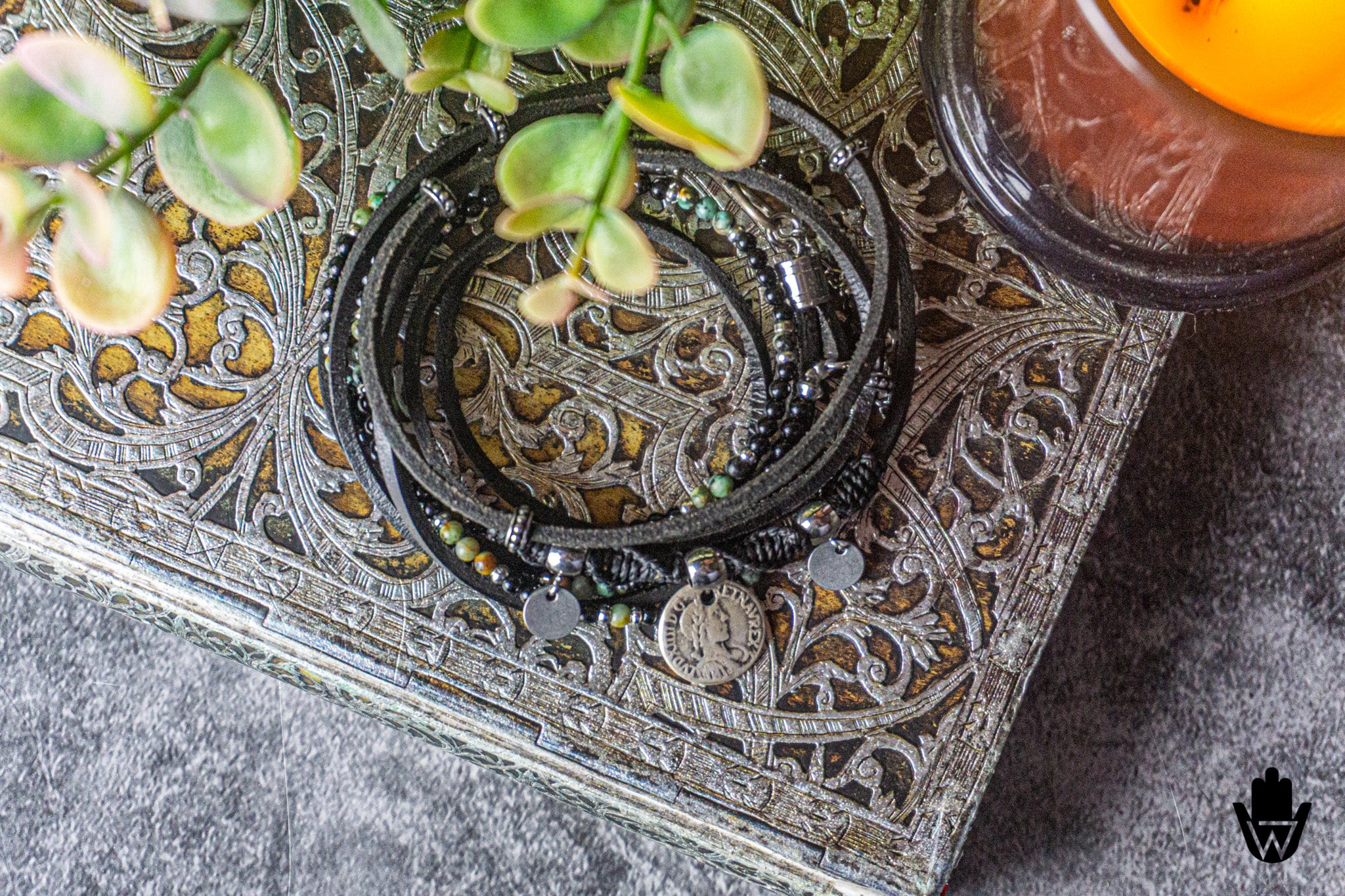 Black leather beaded bracelet set
 on a textured surface.