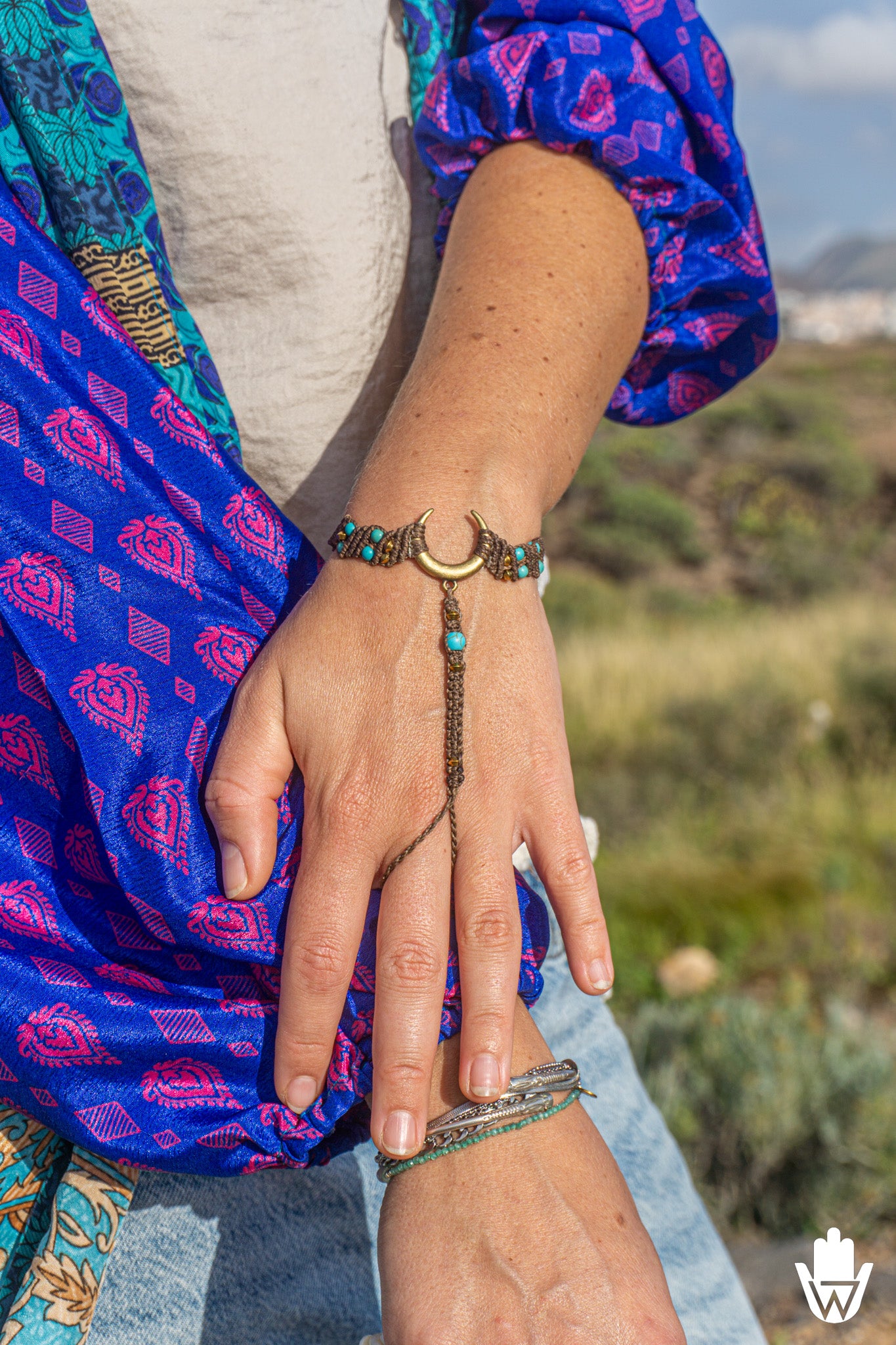 woman wearing a hand-woven macrame bracelets on a blurred natural background