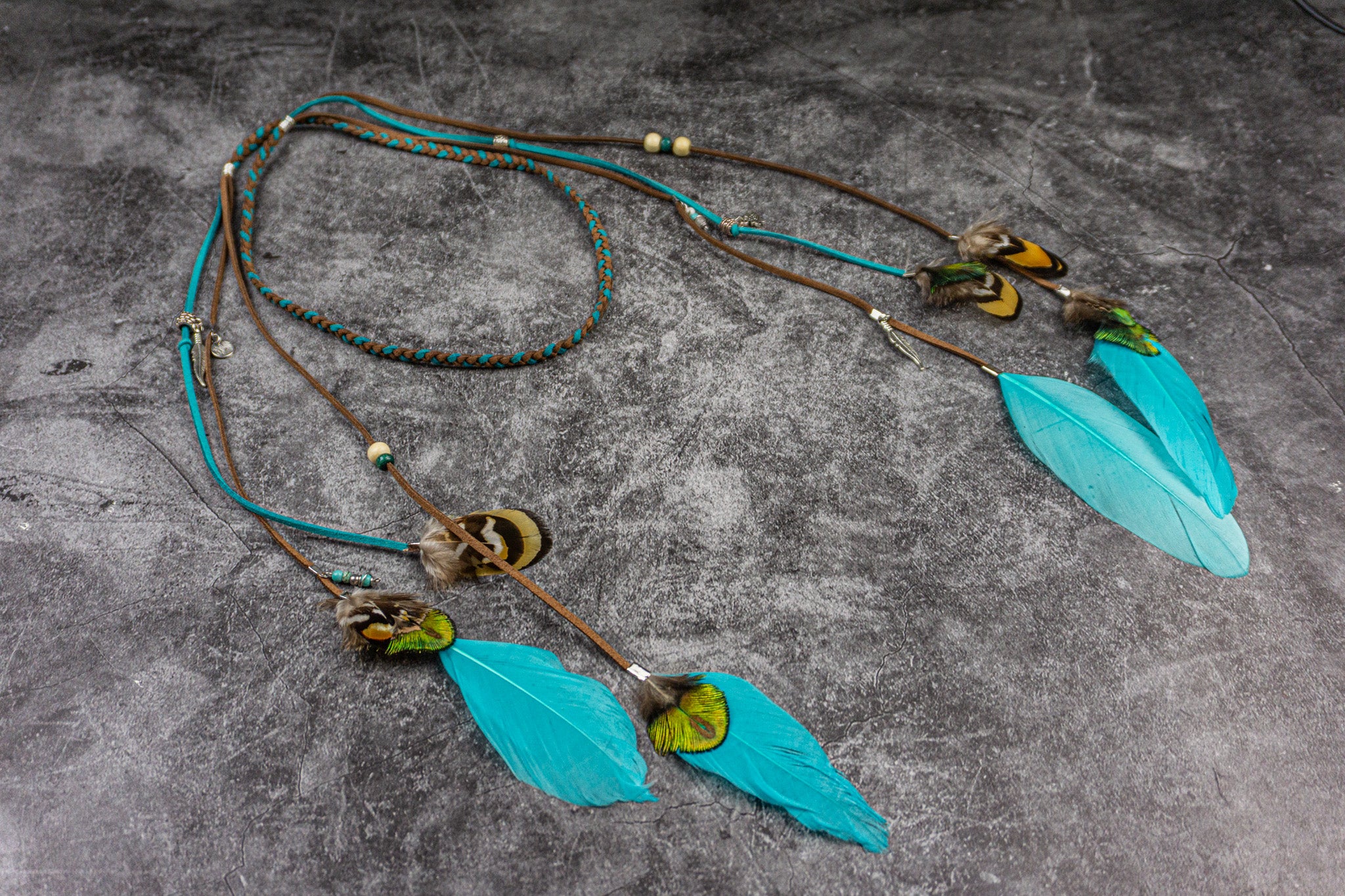 headband with turquoise feathers and beads on a textured surface