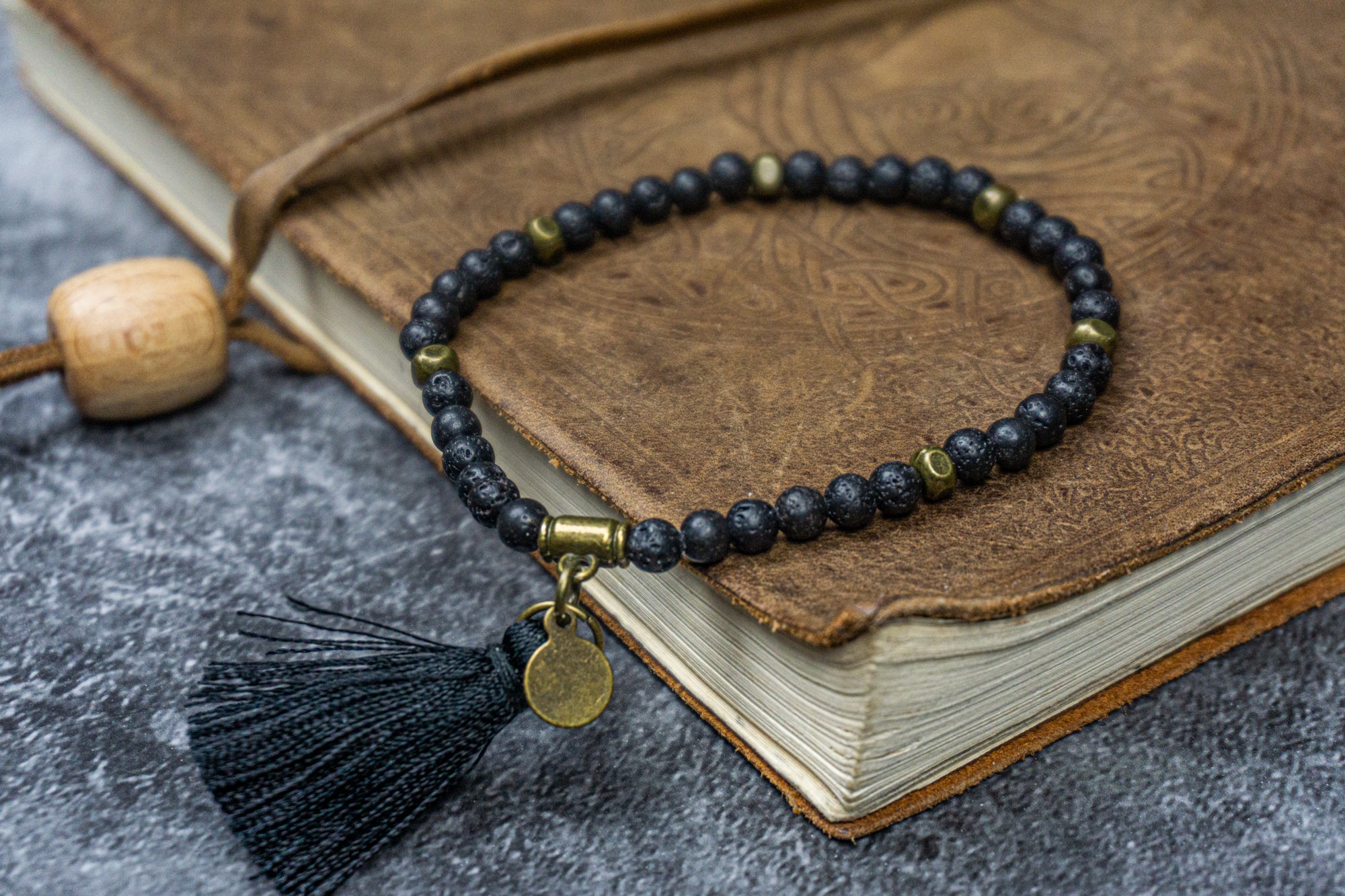 lava stone beaded bracelet with a tassel and a little bronze coin dangle- wander jewellery