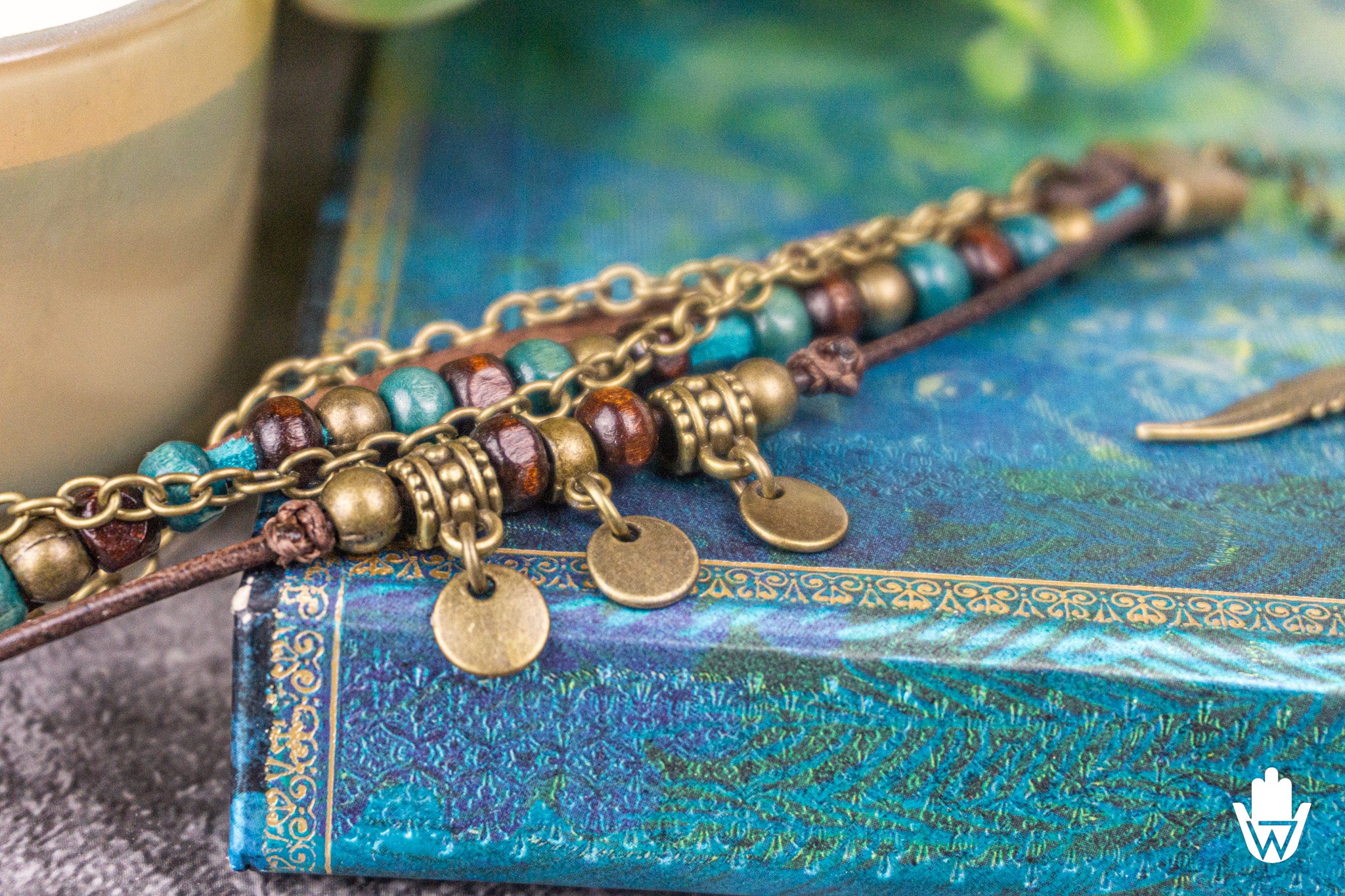Bracelets with beads and coin charms on a textured blue surface