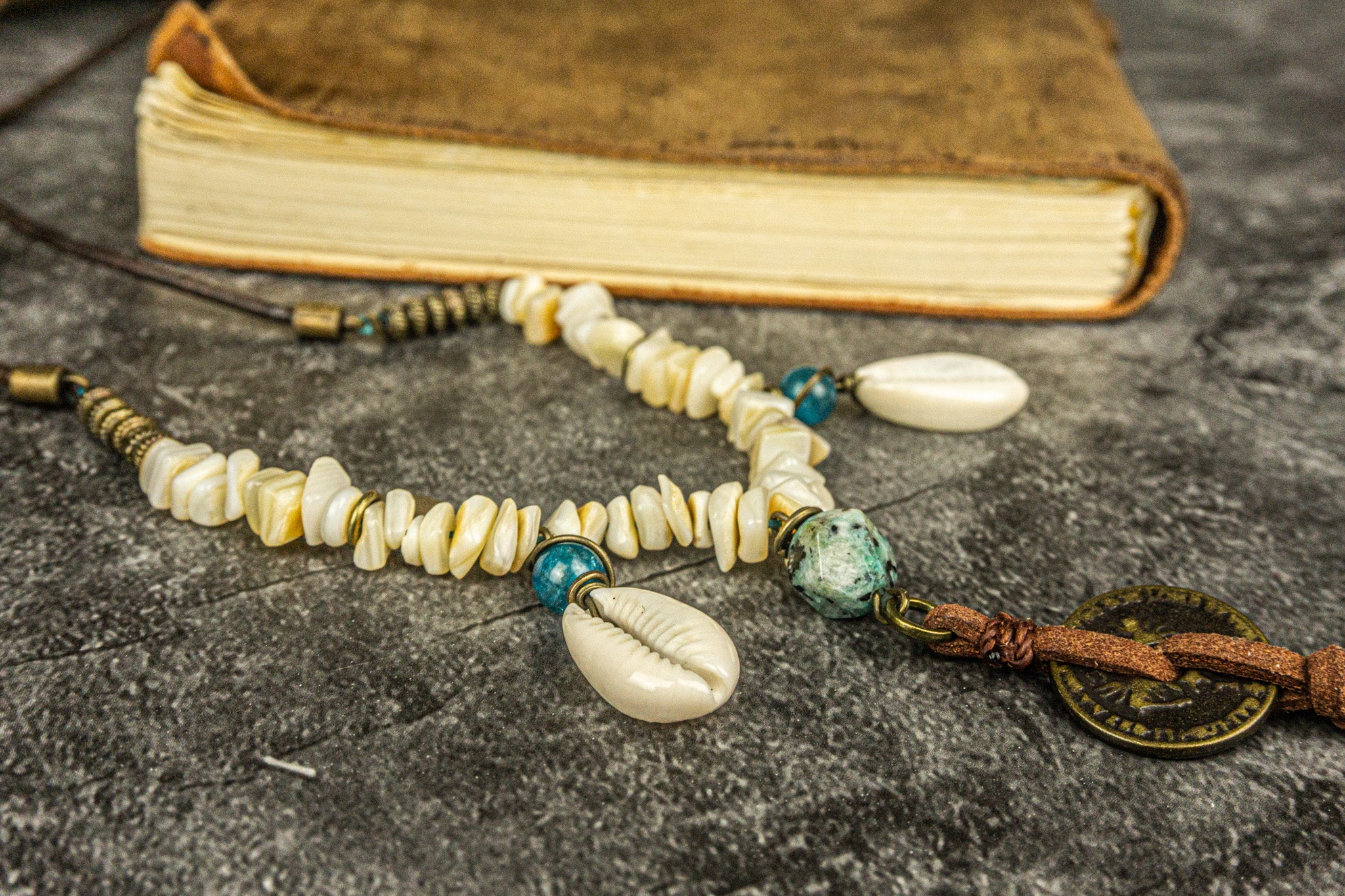long leather beaded necklace made of brass beads and white coral , with coin and cowrie shell charms-wander jewellery