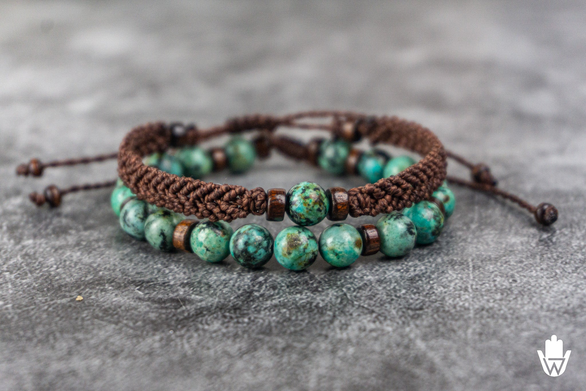 Two african turquoise beaded bracelets on a gray surface