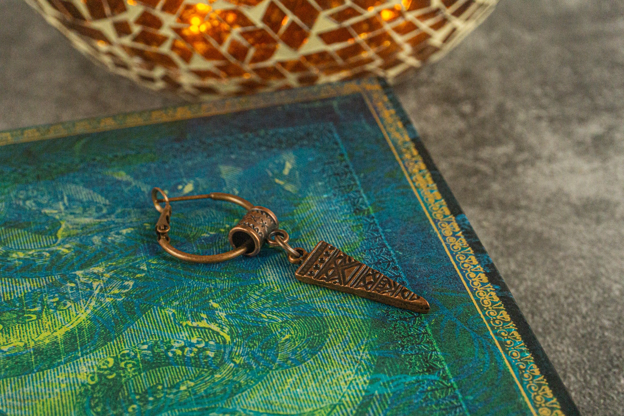 single copper hoop earring with a copper triangle tribal charm pendant- wander jewellery