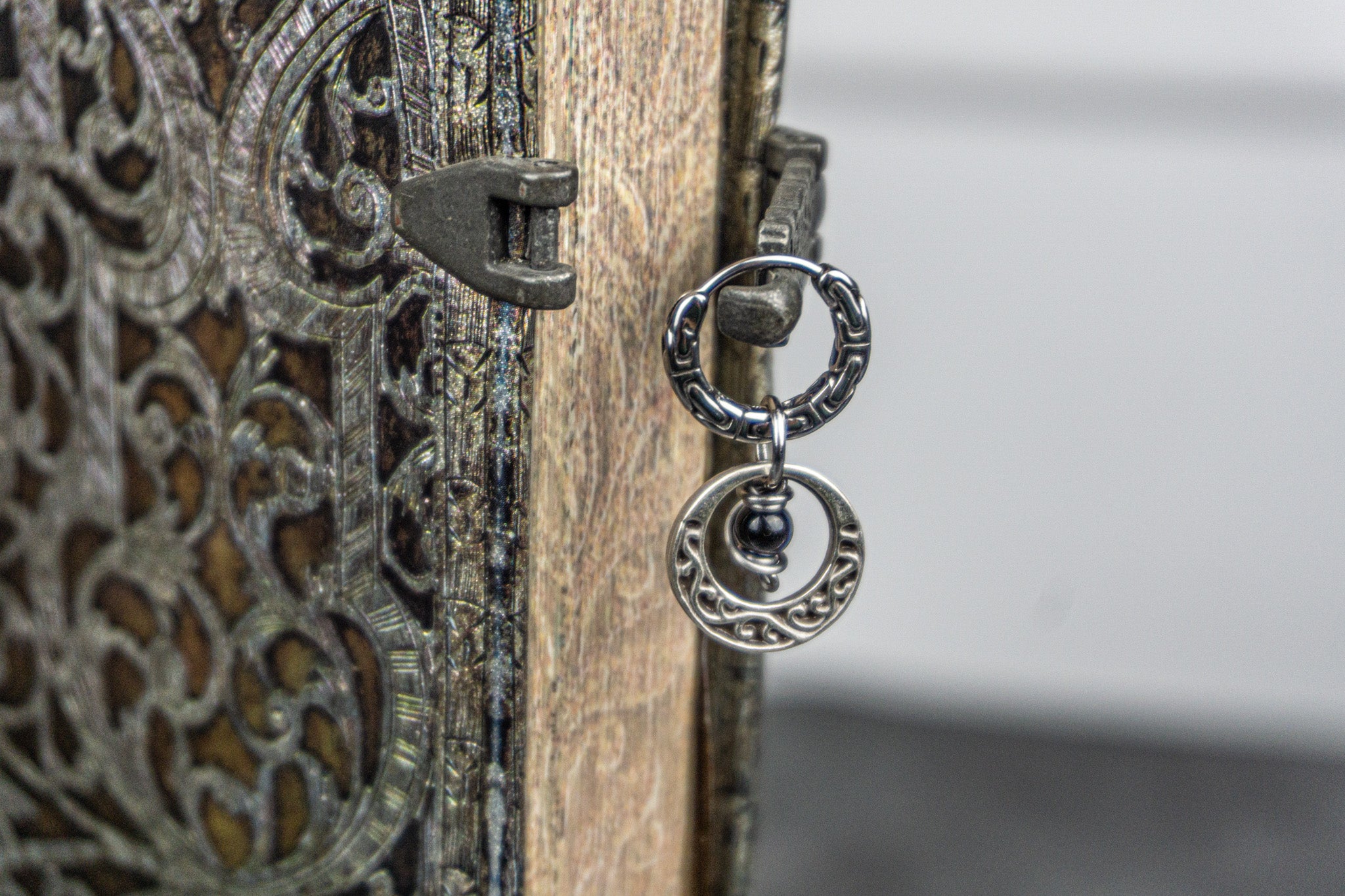 cool stainless steel hoop earring with an abstract moon charm with a dangle onyx bead- wander jewellery