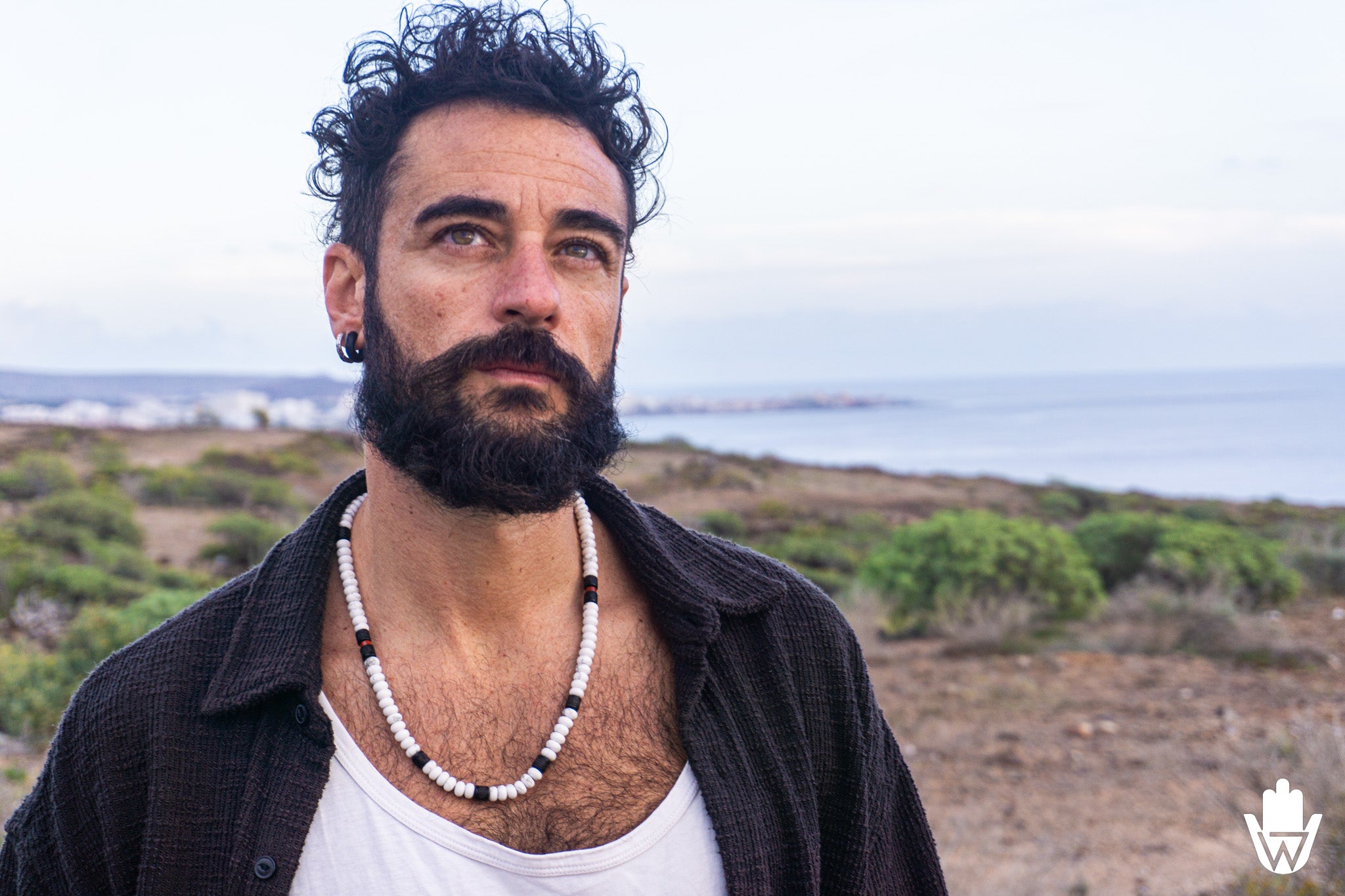 mens in a natural enviroment with a chunky white bead necklace
