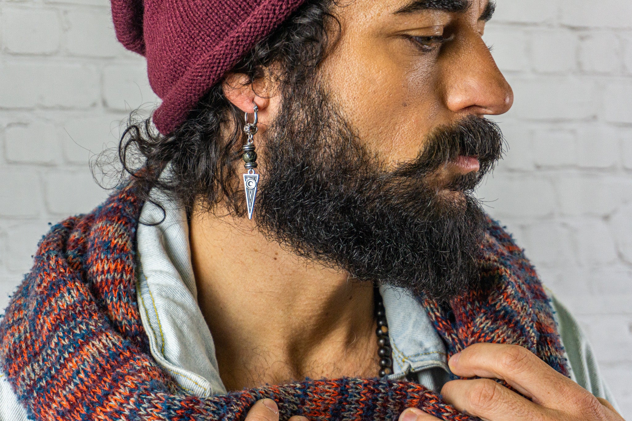 men with scarf and beanie with a long spike earring with a pyrite stone