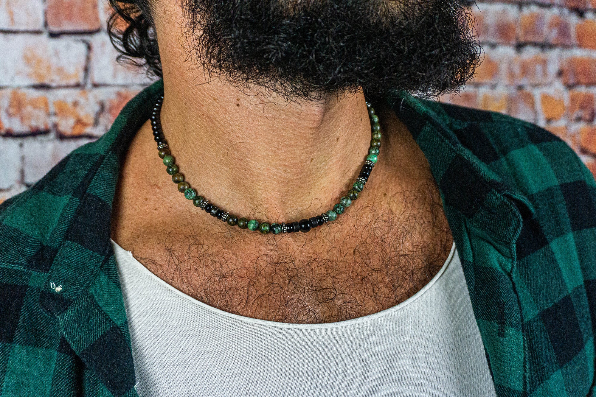 men waering a black and green gemstone beads choker necklace with some stainless steel details