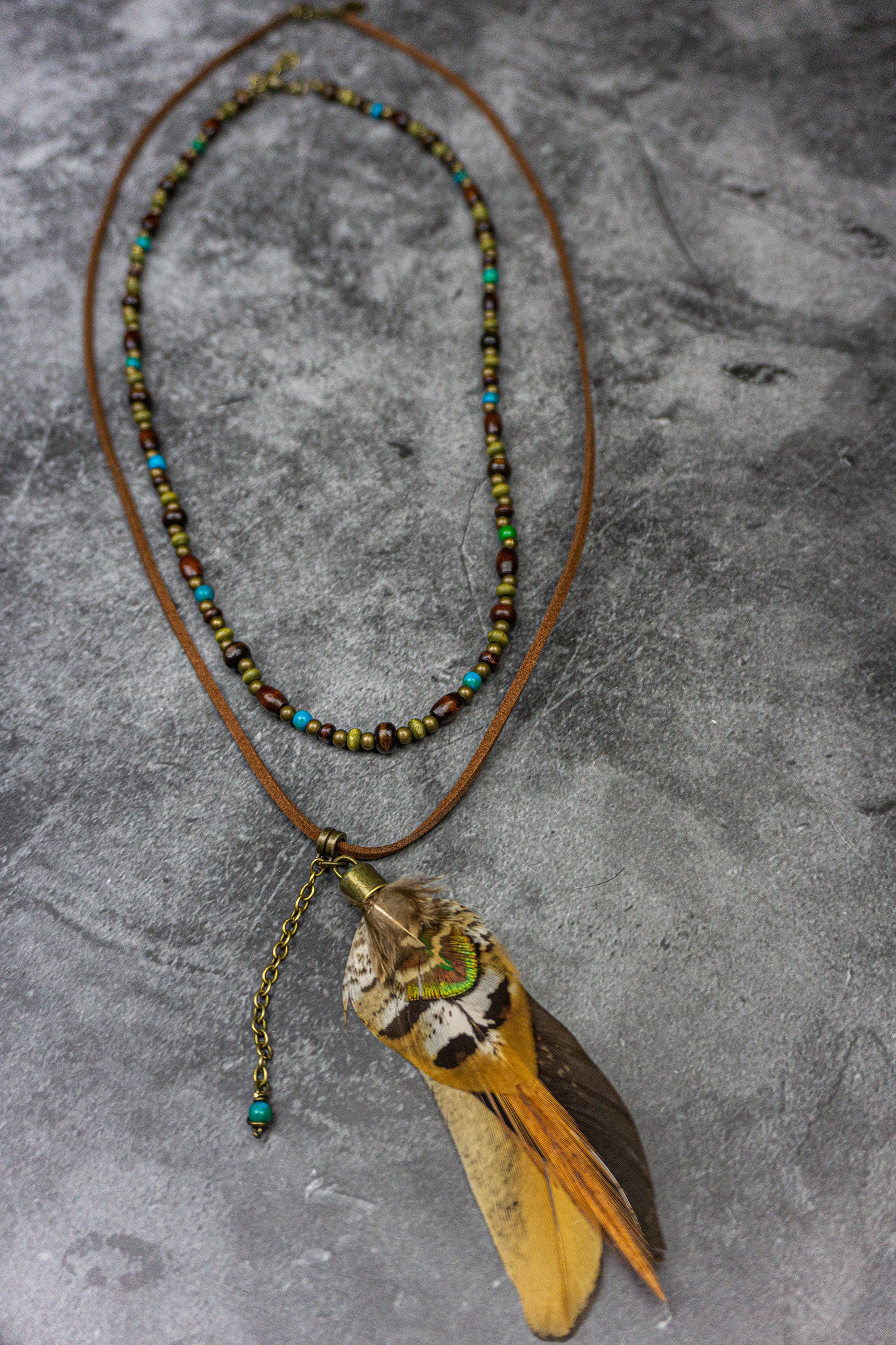 necklace set made of one wooden beaded necklace and a feather pendant necklace made of leather