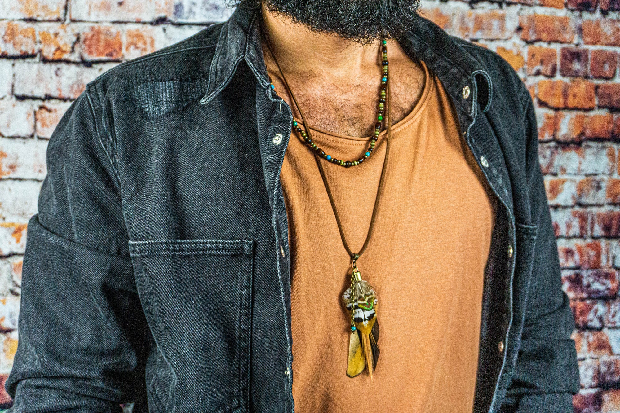 men wearing a boho necklace setof 2, with a wooden bead and a leather feather pendant