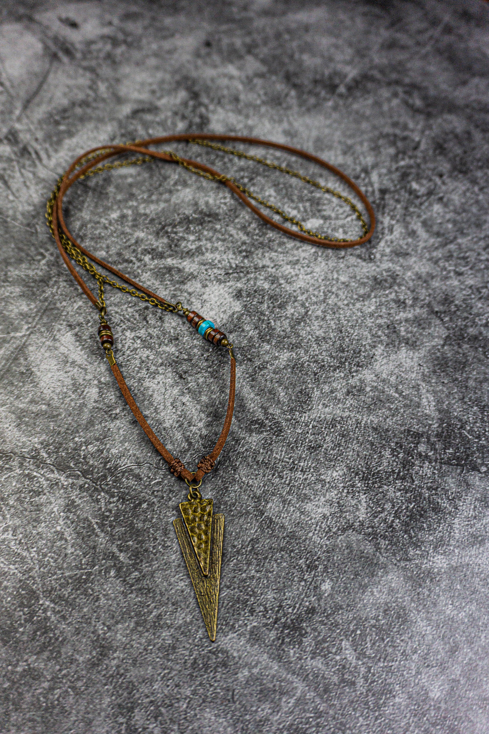 long leather and chain necklace with a triangle arrowead bronze pendant