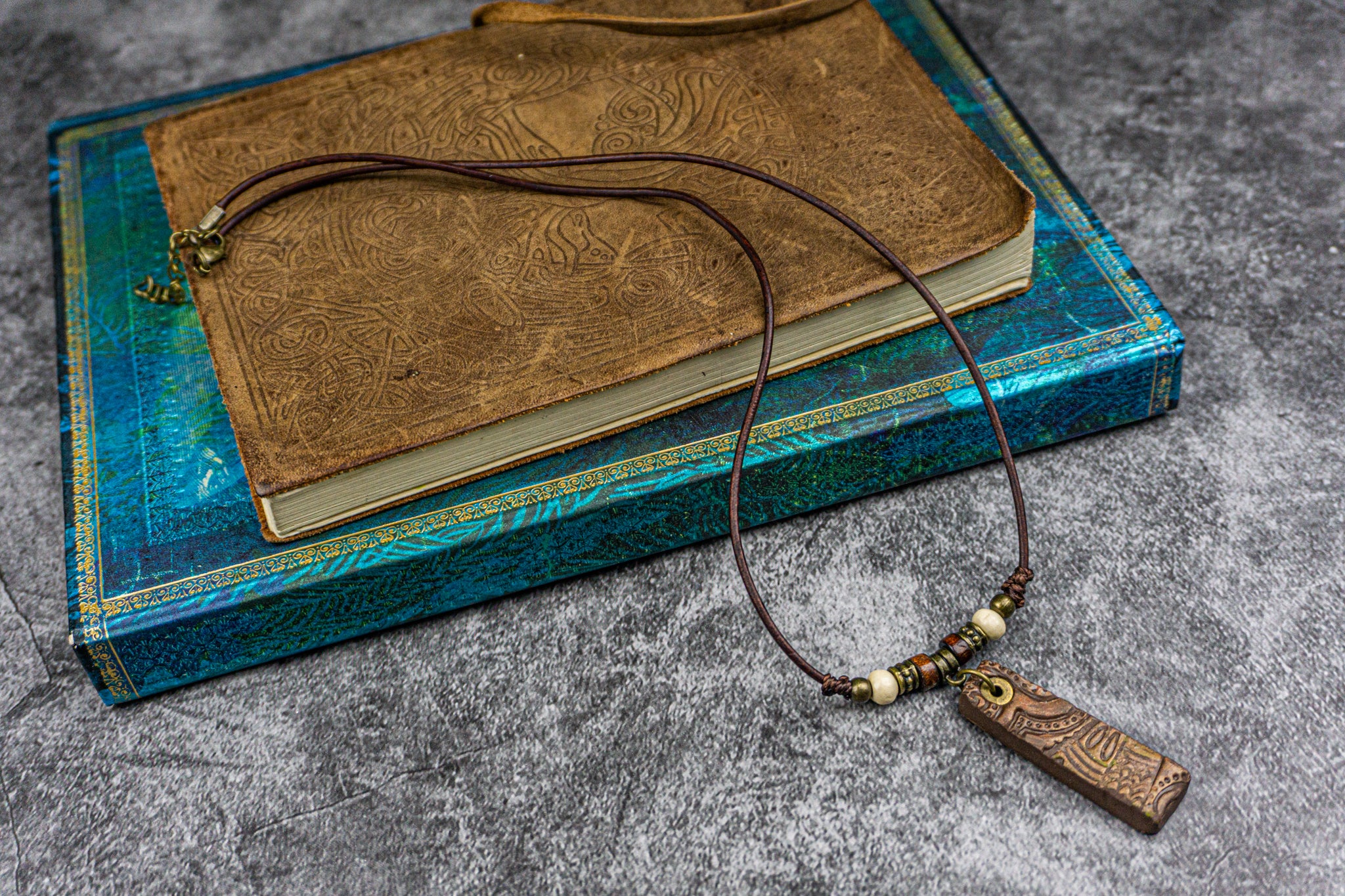 thin leather necklace with brass and wood details and a cool pendant