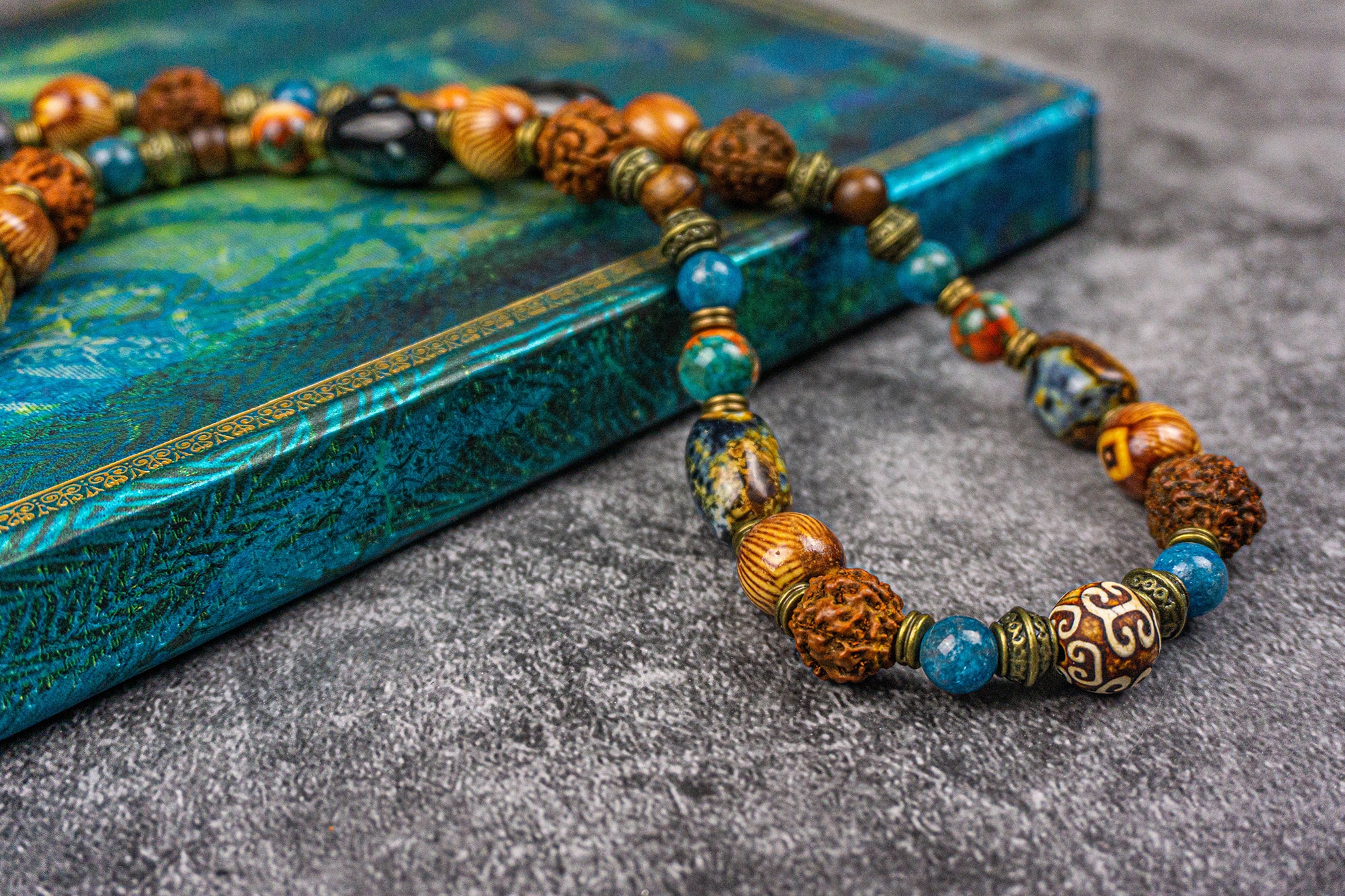 close picture of a multicolors and multibeads necklace made of wood, rudraksha, apatite blue gemstones, big agate fire beads and brass spacer beads- wander jewellry